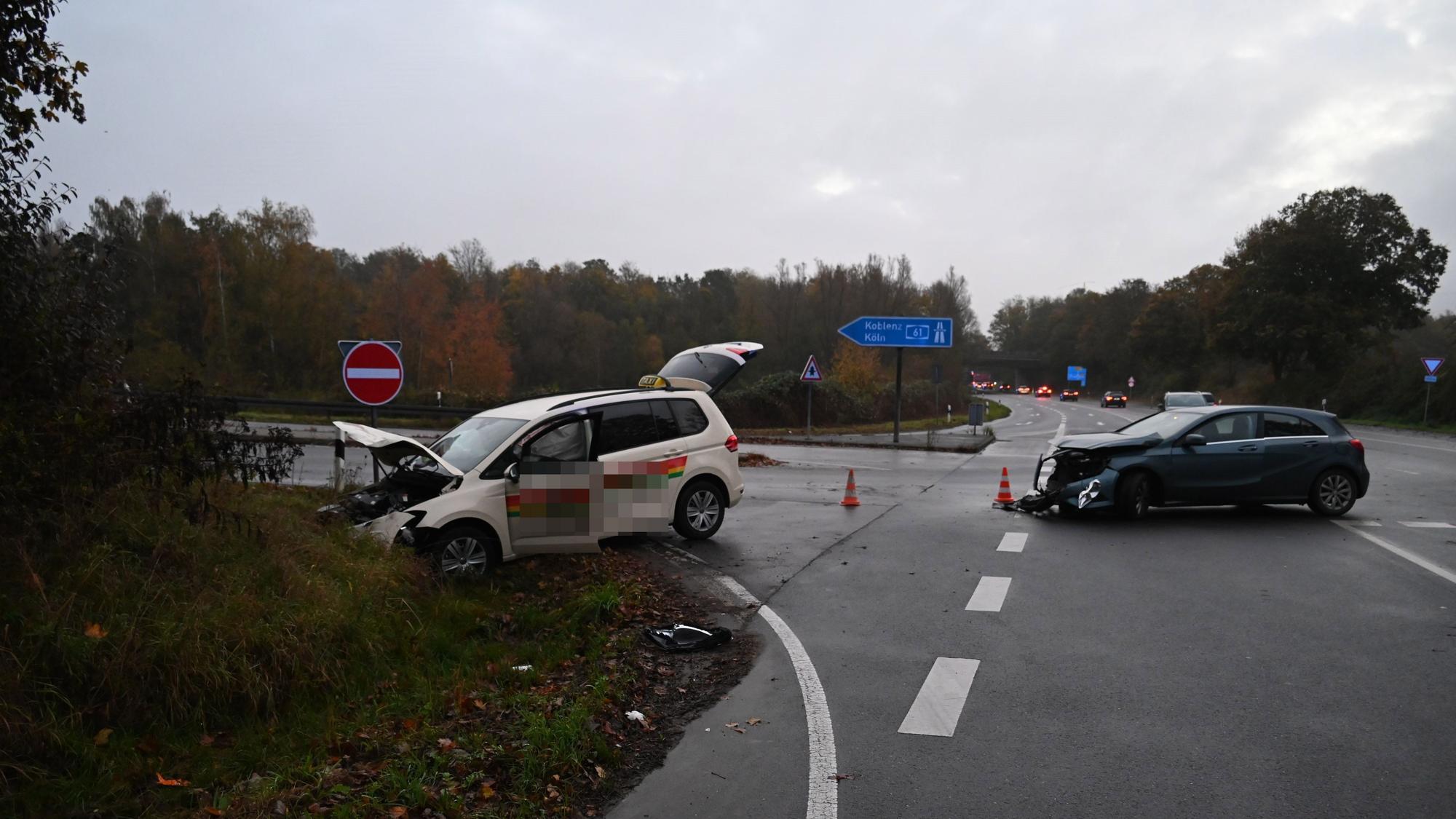 Zwei beschädigte Autos stehen auf einer Straße.