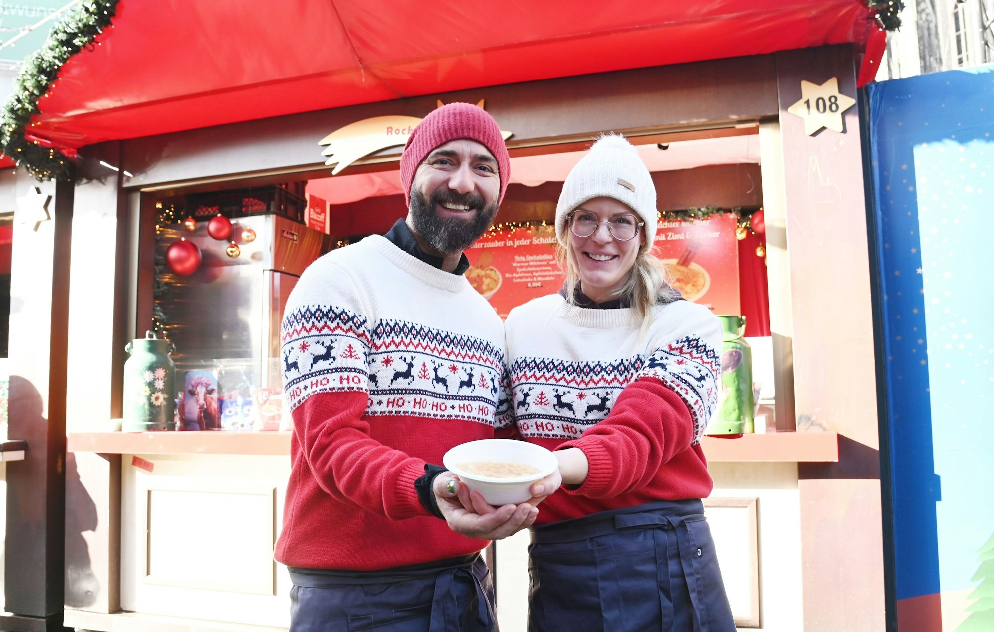 Carina Spanier und Volkan Gerdan halten Milchreis in die Kamera.