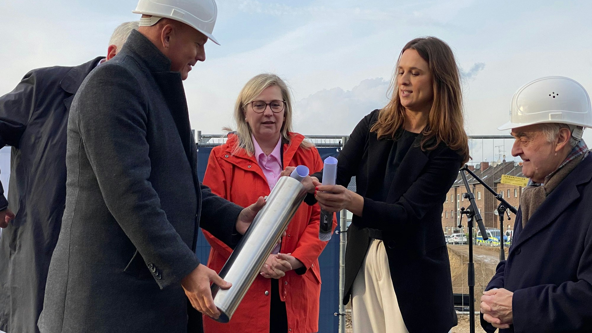 Zu sehen sind die für den Bau verantwortlichen Frauen und Männer, die die Zeitkapsel füllen.