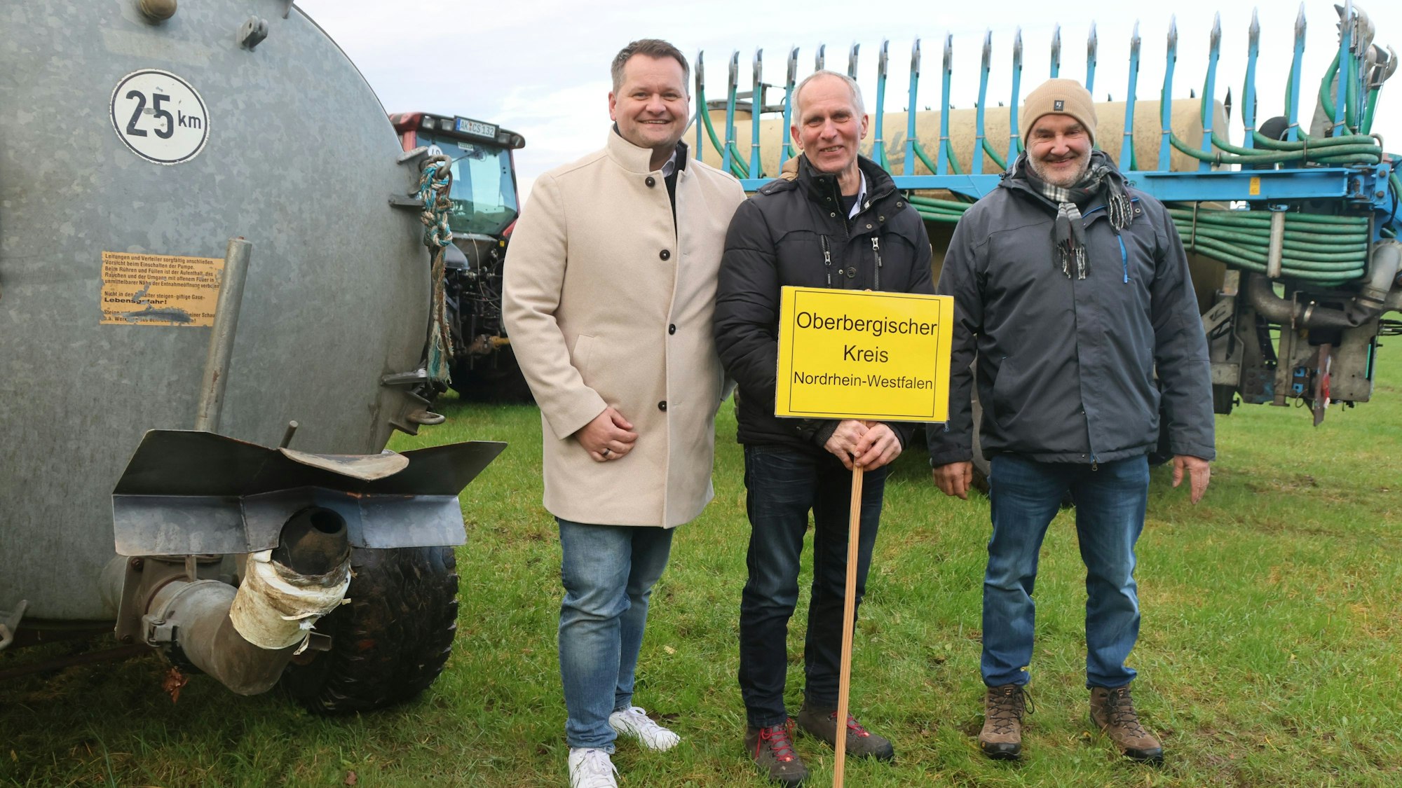 Christian Berger, Franz Bellinghausen und Bernd Schnippering zwischen einem Breitverteiler und einem Anhänger mit Schleppschuhsystem.