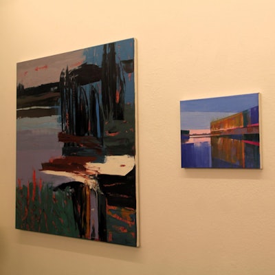 An einer Wand hängen drei Gemälde nebeneinander.
