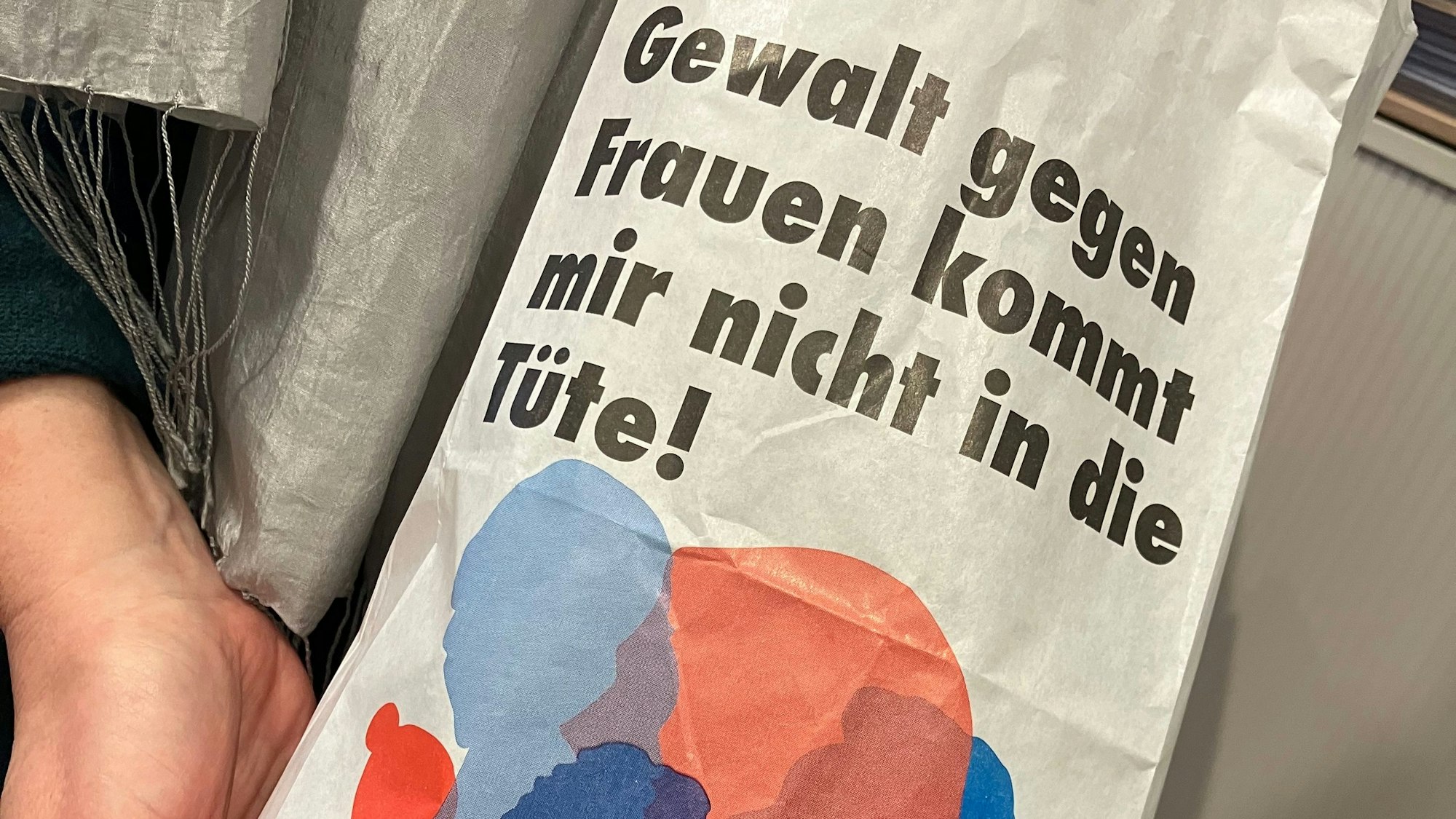 Jemand hält eine Brötchentüte mit einer Aufschrift