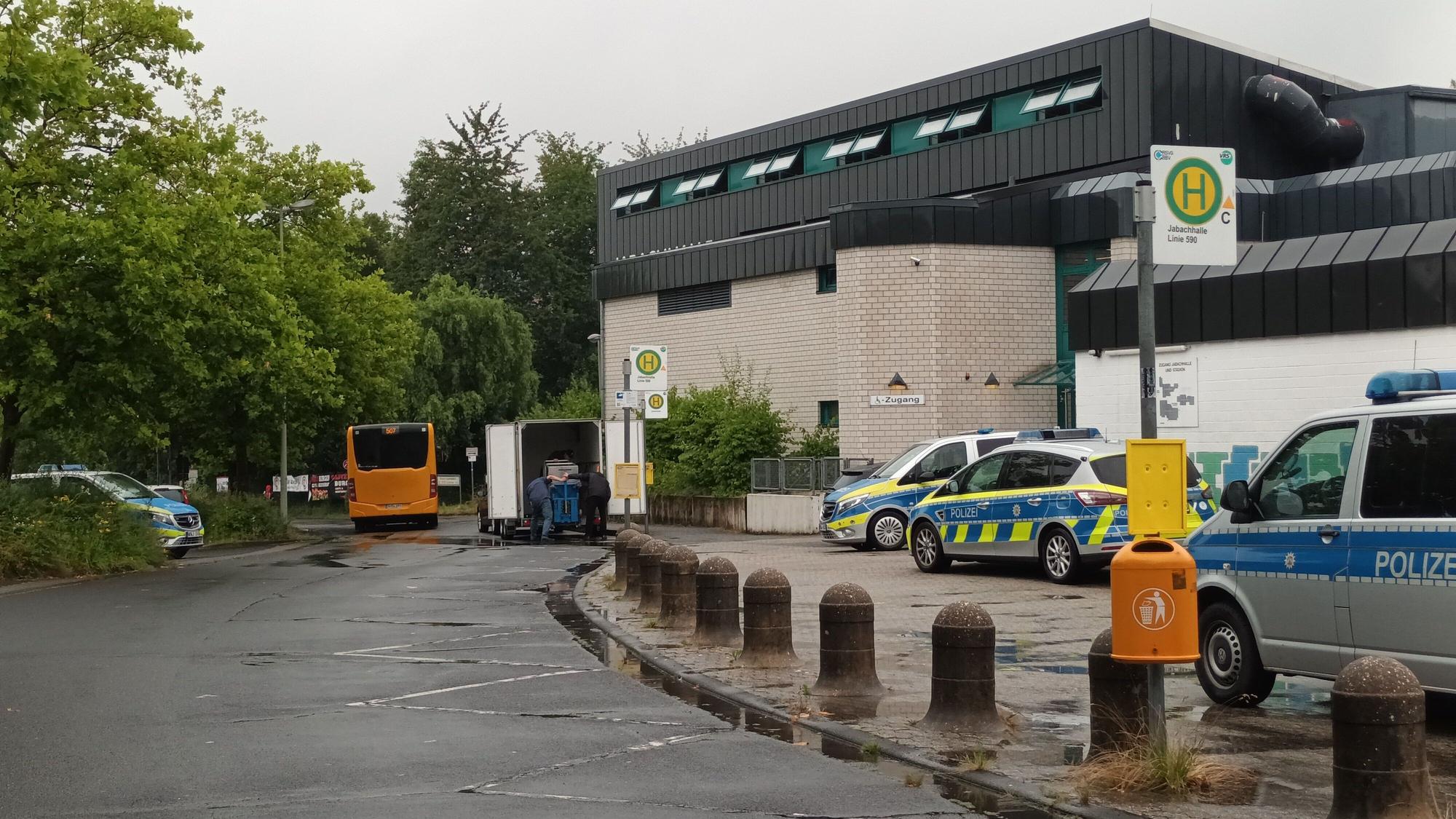 Mehrere Streifenwagen stehen vor einer Versammlungshalle