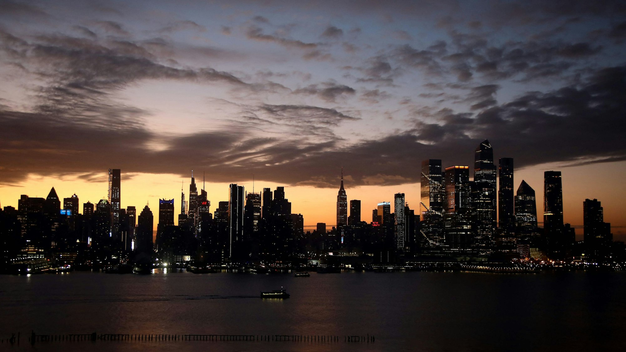 The sun rises behind the skyline of Manhattan in New York City on Election Day, as seen from Weehawken, New Jersey on November 5, 2024. (Photo by Leonardo Munoz / AFP)