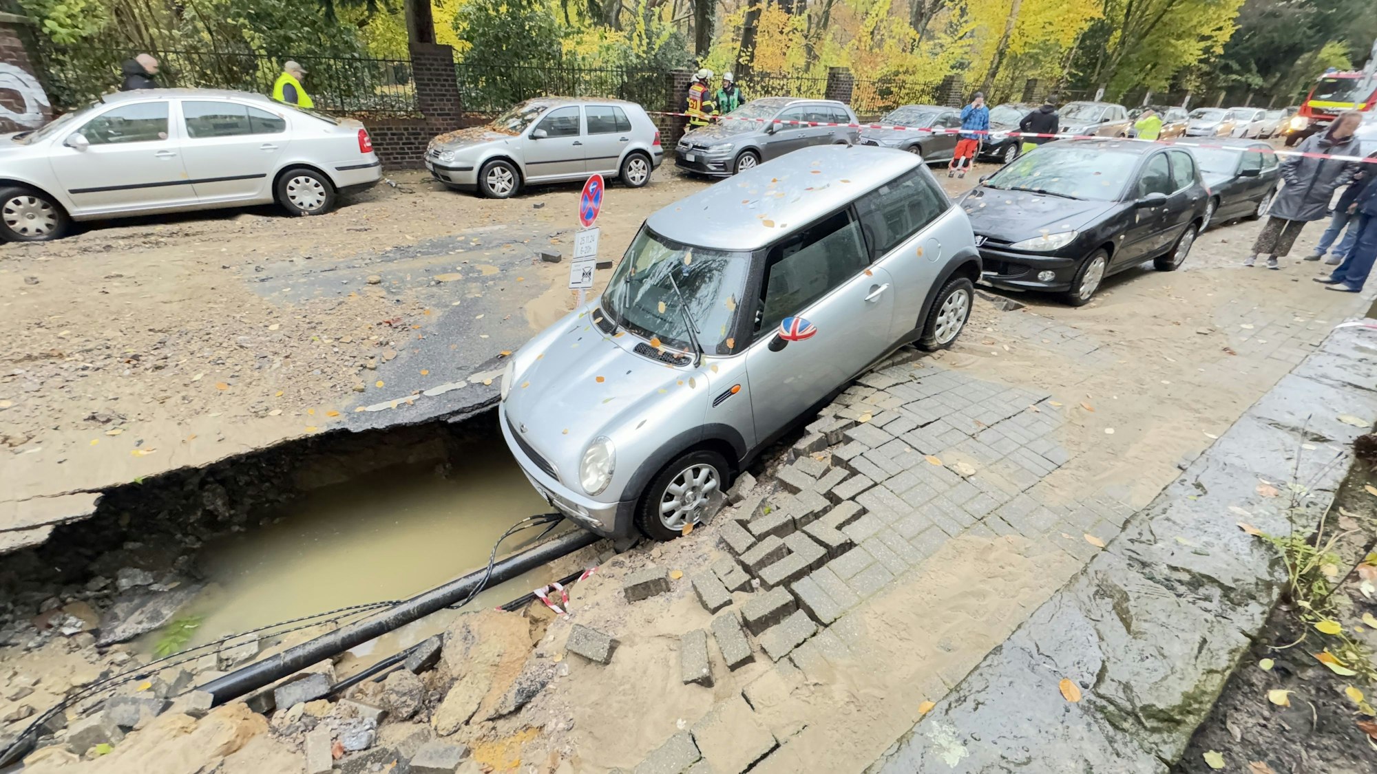 Das Auto rutschte zur Hälfte in das Loch, das sich nach dem Wasserrohrbruch plötzlich auftat.