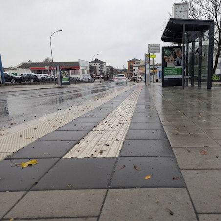 Das Foto zeigt das Pflaster der barrierefrei ausgebauten Haltestelle an der Luxemburger Straße aus der Froschperspektive.