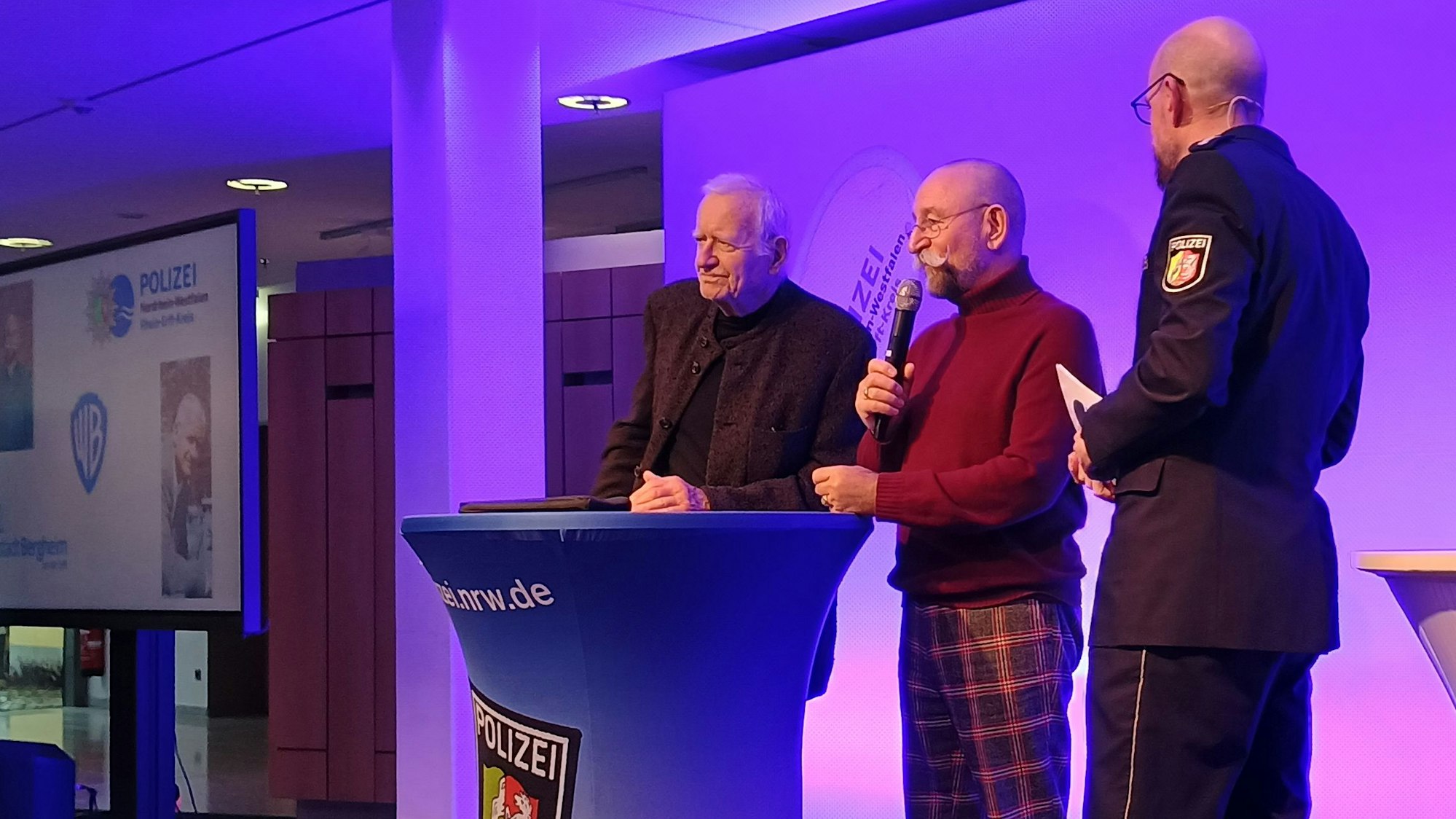 Bongart und Lichter stehen auf der Bühne des Medio Rhein Erft neben einem Pressesprecher der Polizei.