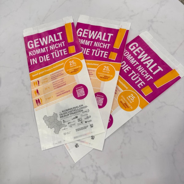 Brötchentüten mit der Aufschrift „Gewalt kommt uns nicht in die Tüte!“ liegen bereit, um im Rhein-Erft-Kreis verteilt zu werden.