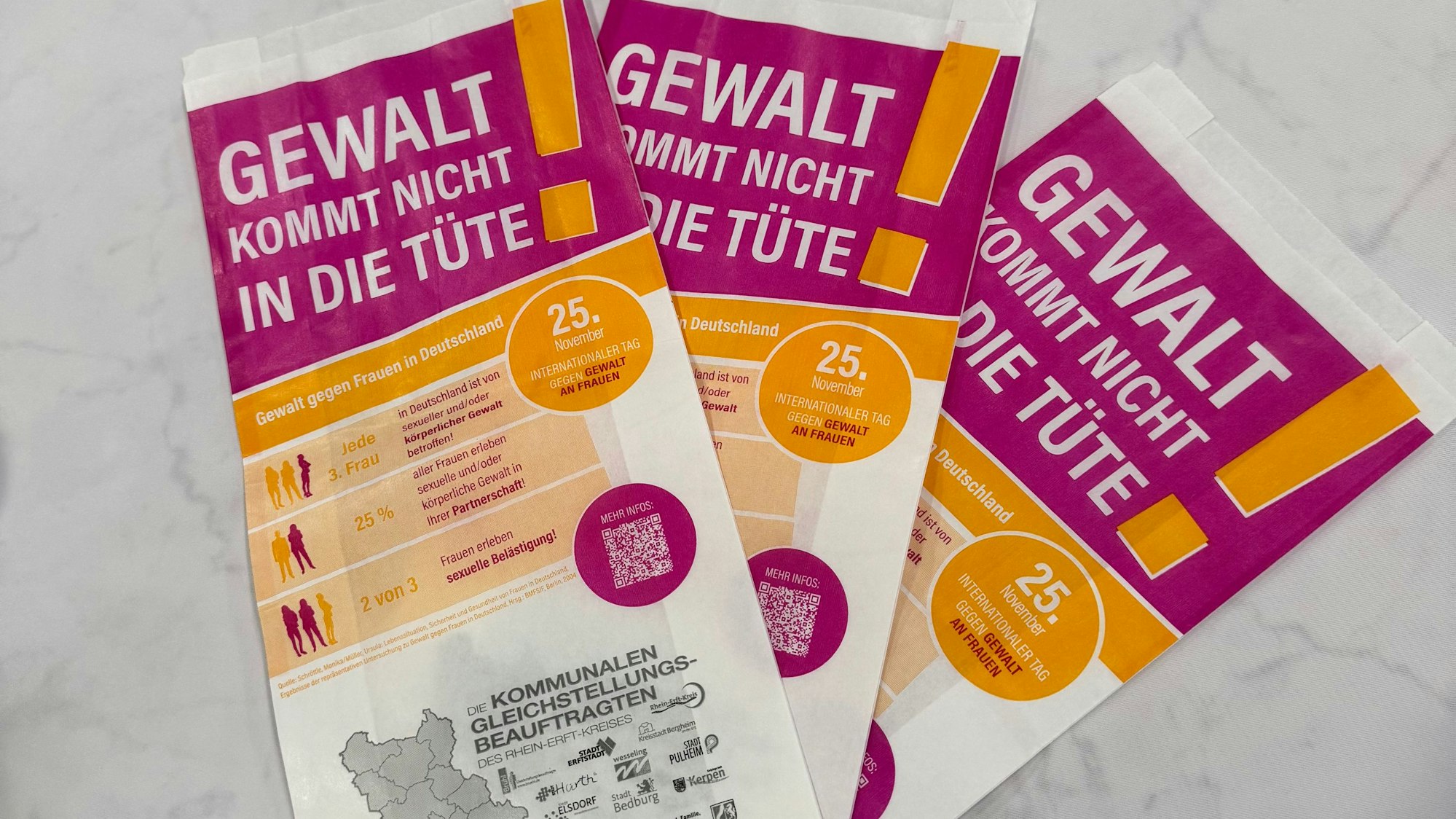 Brötchentüten mit der Aufschrift „Gewalt kommt uns nicht in die Tüte!“ liegen bereit, um im Rhein-Erft-Kreis verteilt zu werden.