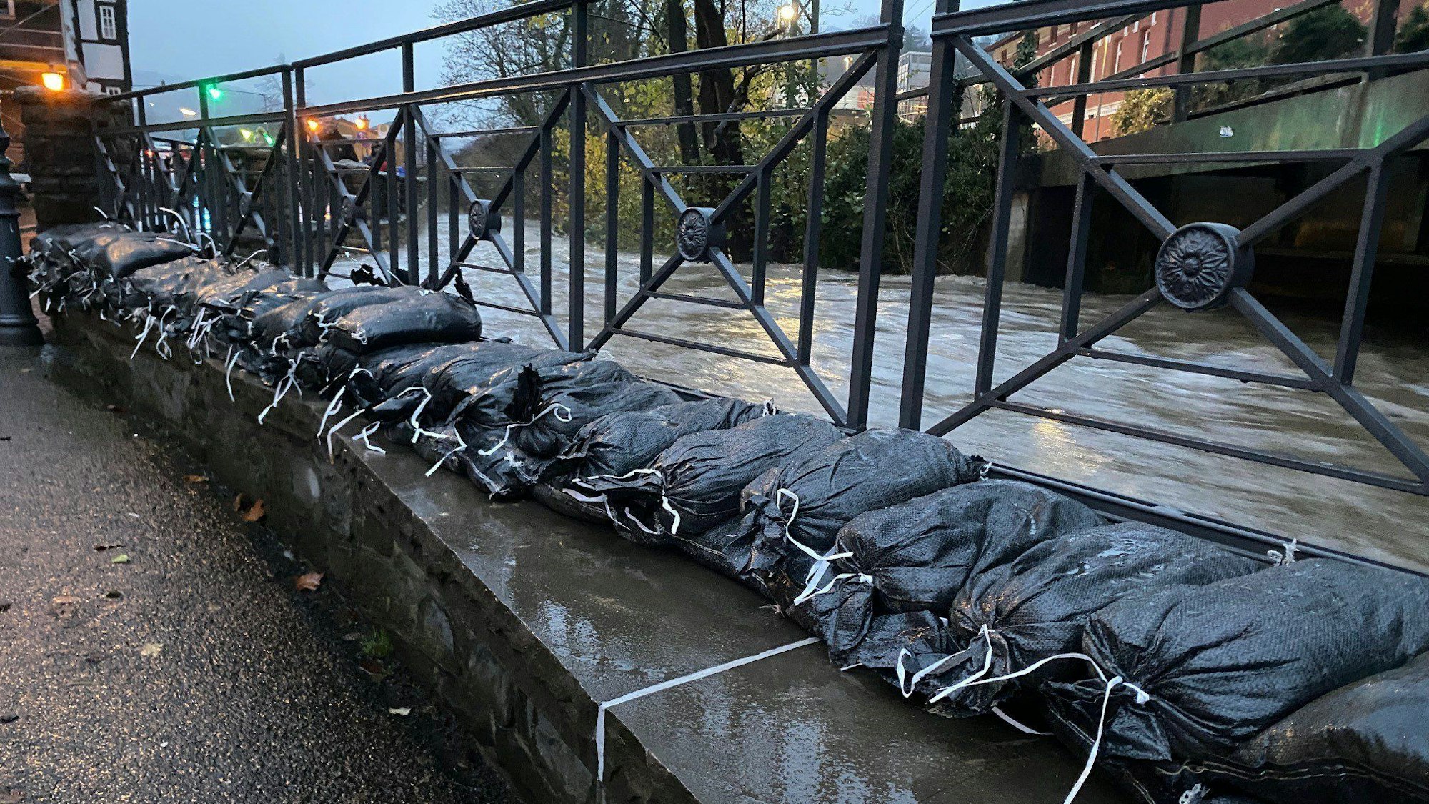 Sandsäcke sollen die Ufer des Deilbachs in Velbert-Langenberg schützen. Aufgrund des Dauerregens sind in dem Ortsteil Keller vollgelaufen und Straßen überflutet.