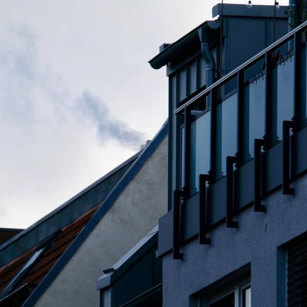 Ein rauchender Schornstein auf einem Dach in Sülz.