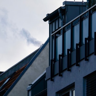 Ein rauchender Schornstein auf einem Dach in Sülz.