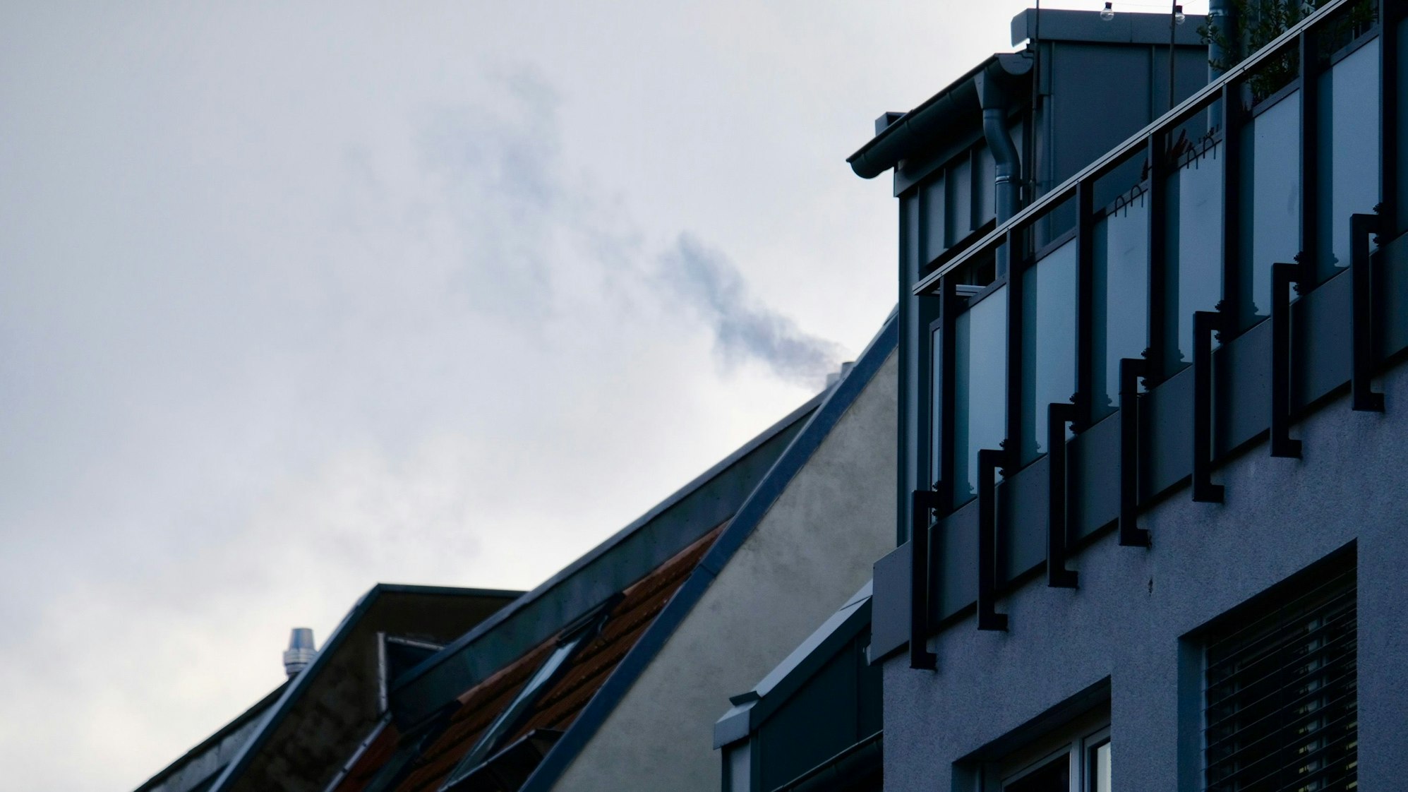 Ein rauchender Schornstein auf einem Dach in Sülz.