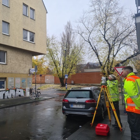 Blick auf eine T-Kreuzung, an der ein sehr großes gelbes heruntergekommenes Haus steht.
