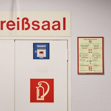 «Kreißsaal» und ein Richtungspfeil stehen auf einem Schild über einer Tür in einer Klinik.