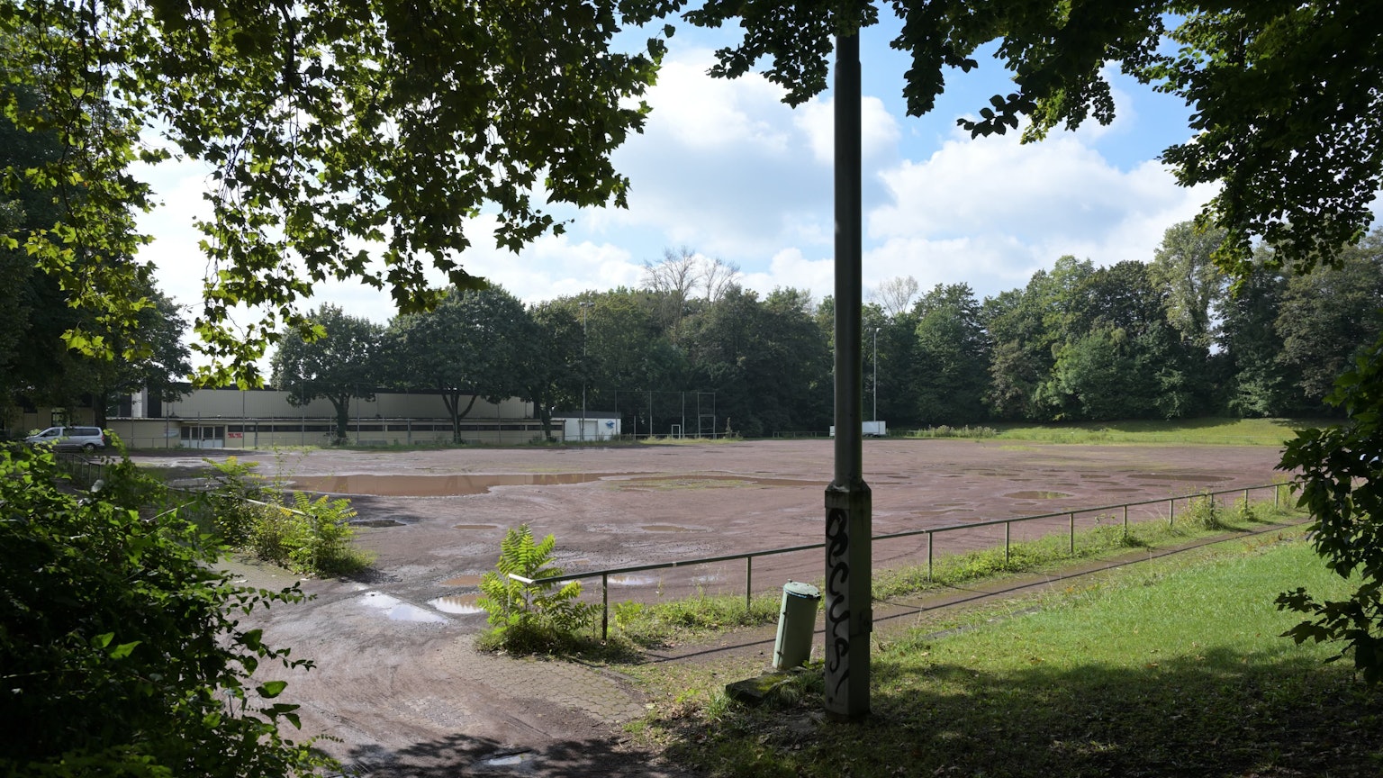 Auf dem brach liegenden Aschenplatz stehen Pfützen.