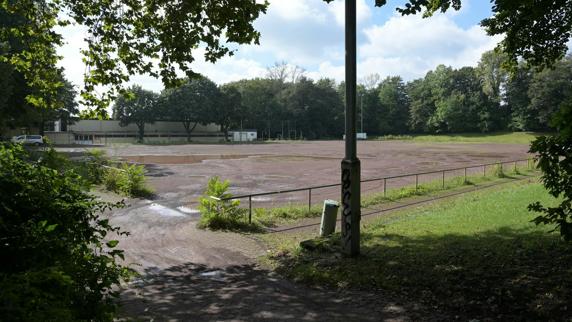 Auf dem brach liegenden Aschenplatz stehen Pfützen.