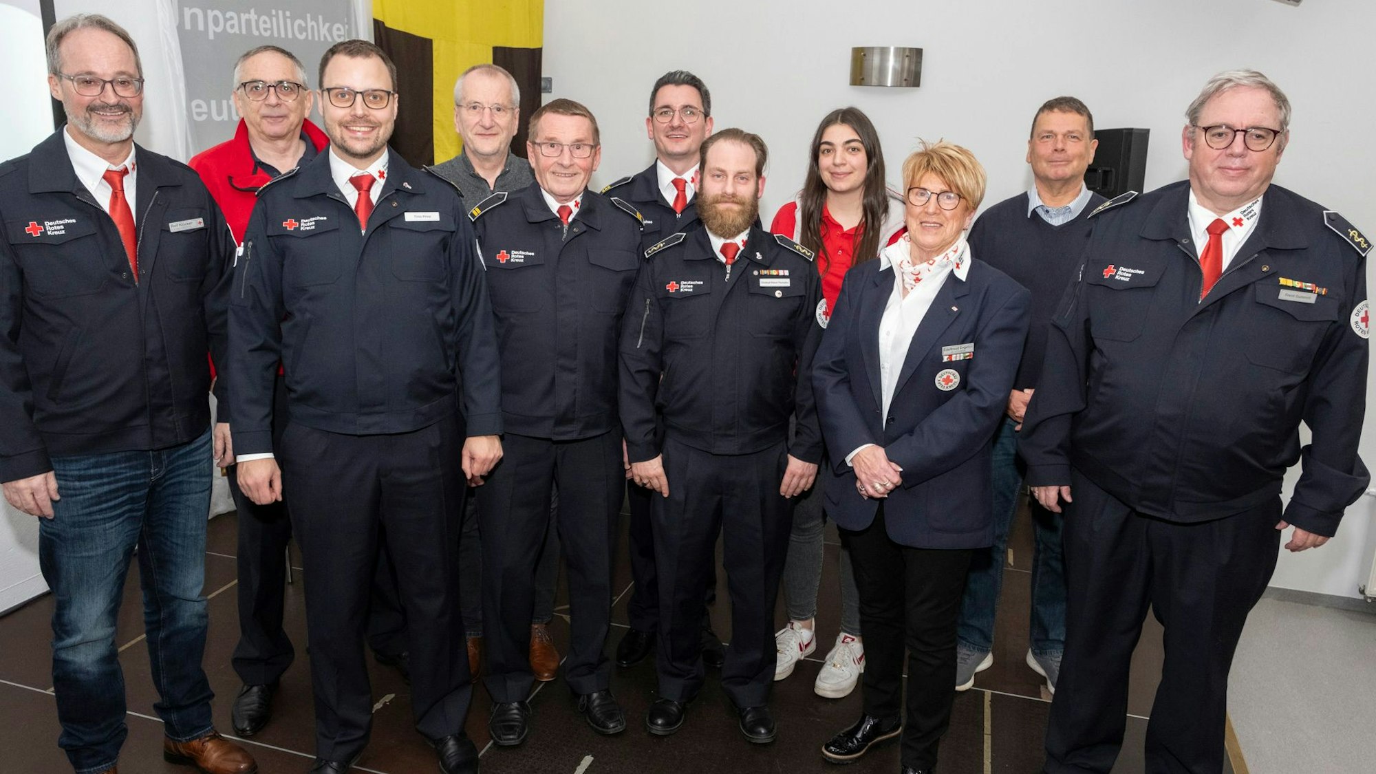 Menschen haben sich in einem Innenraum für ein Foto als Gruppe aufgestellt.