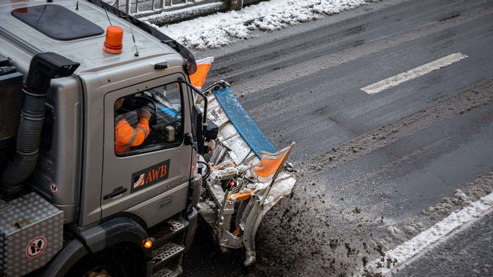 24.01.2021, Köln: Ein mit einem Schneepflug ausgerüstet Fahrzeug der Abfallwirtschaftsbetriebe Köln (AWB) räumt mit seinem Räumschild Schnee und streut Streusalz auf der Straße âÄSülzgürtelâÄ. Nach Schneefall liegt in der Stadt eine dünne Schneedecke. Der nasse und schwere Schnee sorgt für matschige Straßen. Foto: Matthias Heinekamp
