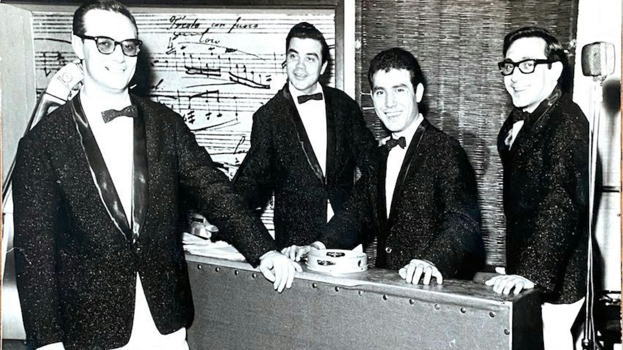 Das Schwarz-Weiß-Foto zeigt vier Musiker, adrett gekleidet mit Anzügen und Fliegen.