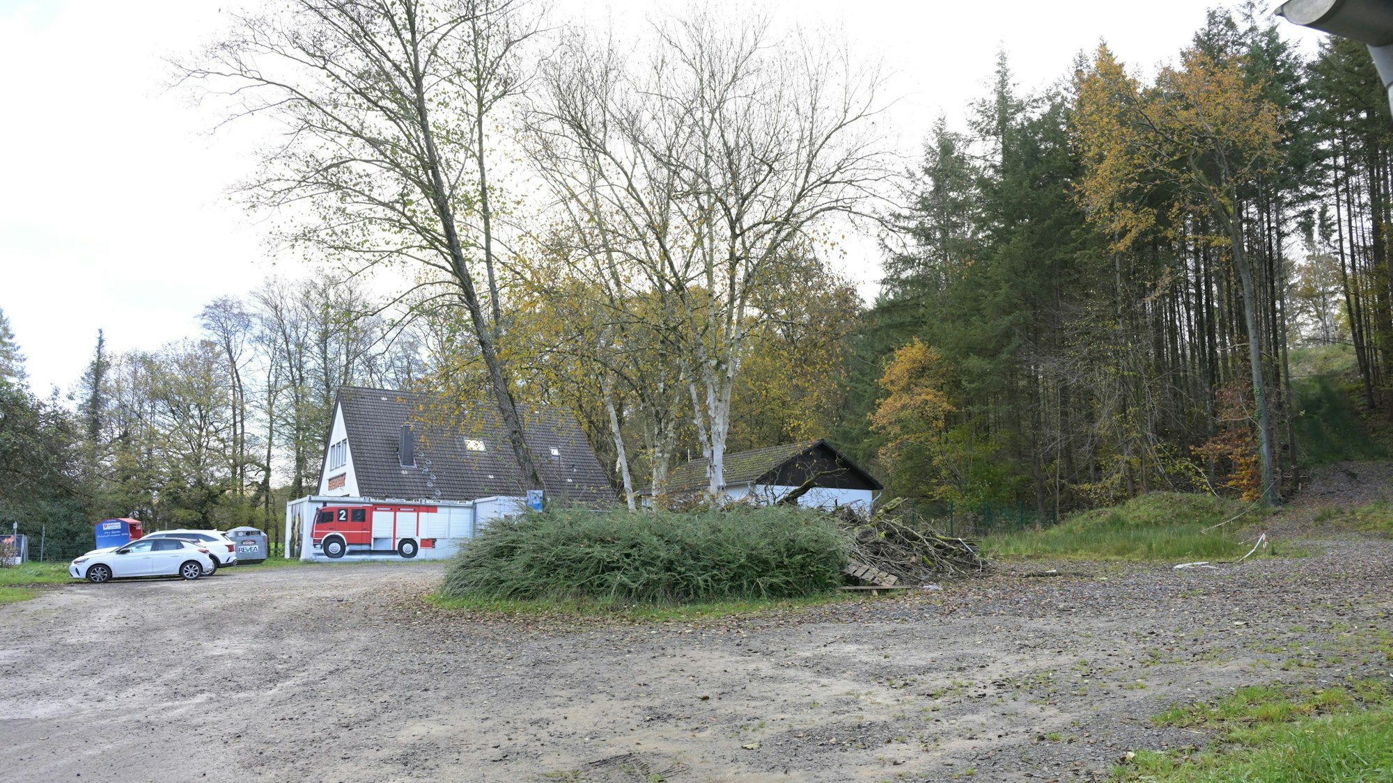 Ein Parkplatz, im Hintergrund ein Feuerwehrgerätehaus.