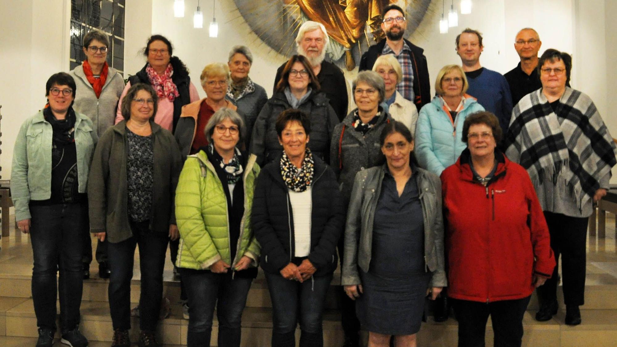 Männer und Frauen haben sich in einer Kirche für ein Foto zusammengestellt.