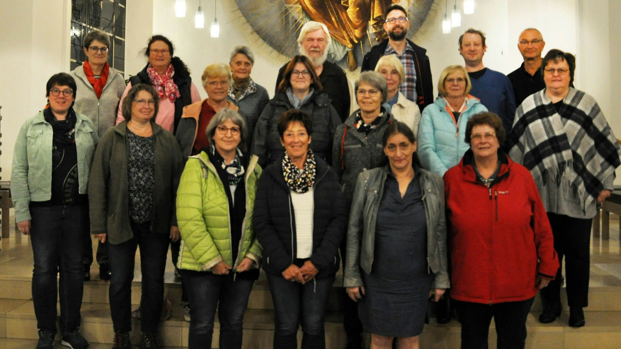 Männer und Frauen haben sich in einer Kirche für ein Foto zusammengestellt.