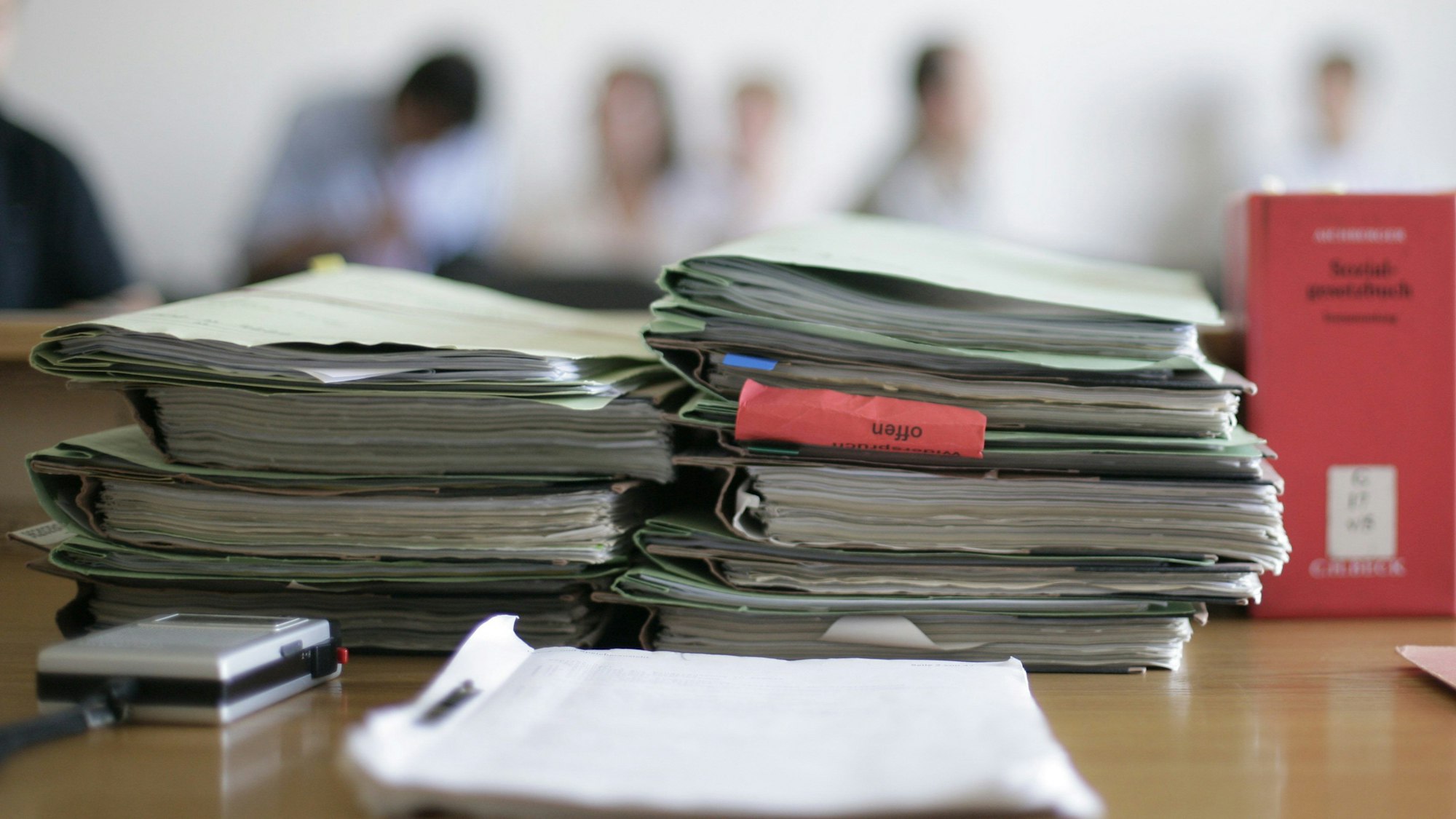 Aktenordner liegen im Gericht zu Beginn einer Verhandlung auf dem Tisch.