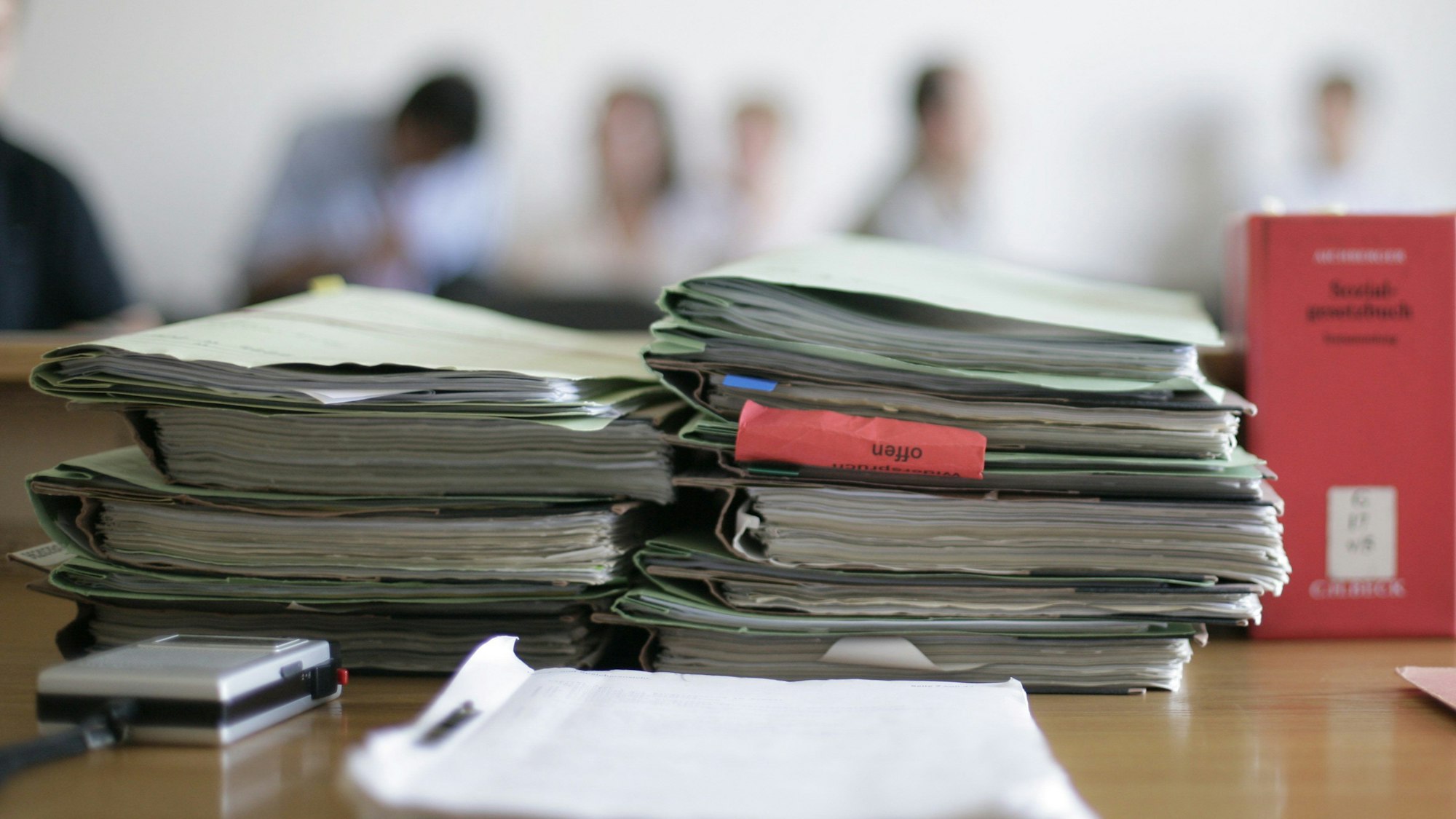 Aktenordner liegen im Gerichtssaal zu Beginn einer Verhandlung auf dem Tisch.