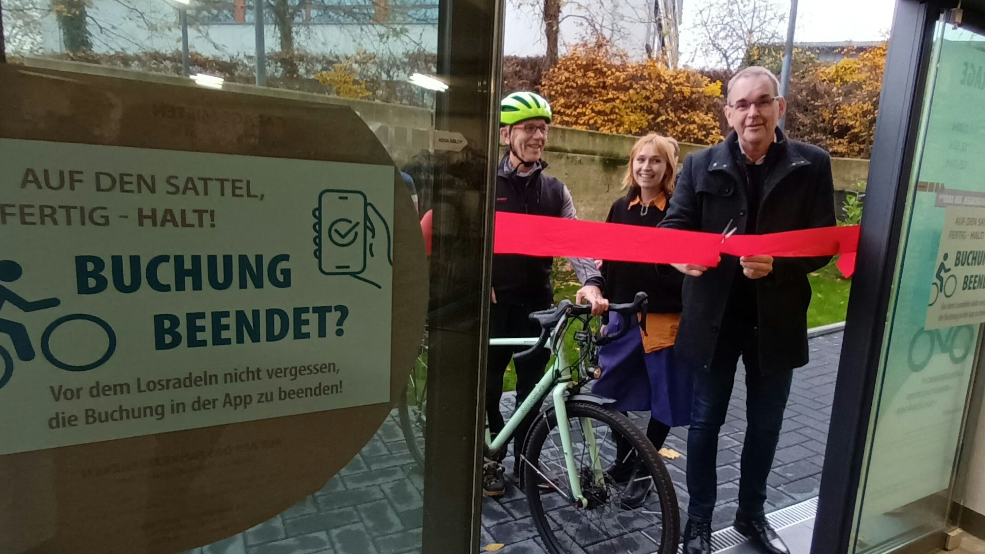 Ein Tür mit rotem Band und eine Gruppe Menschen