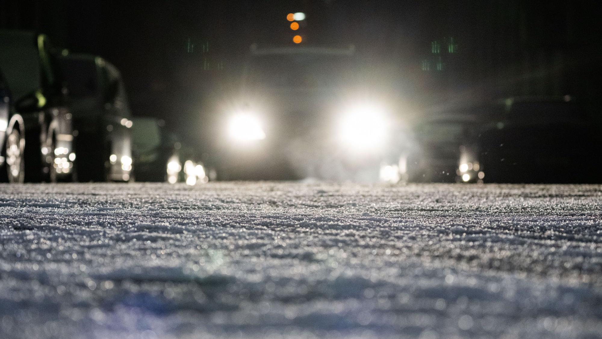 Ein Auto fährt über eine winterliche Straße.