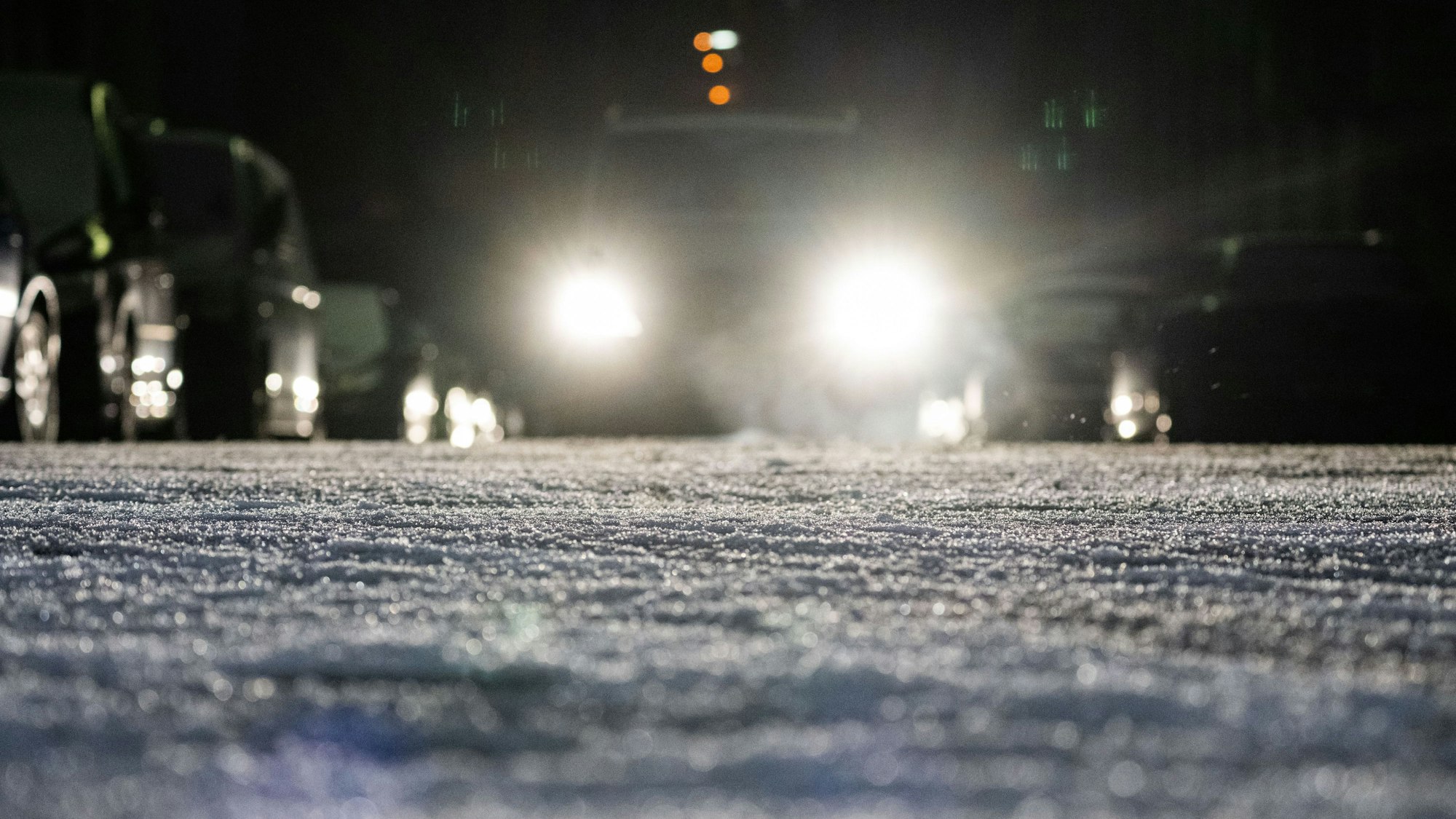 Ein Auto fährt über eine winterliche Straße.