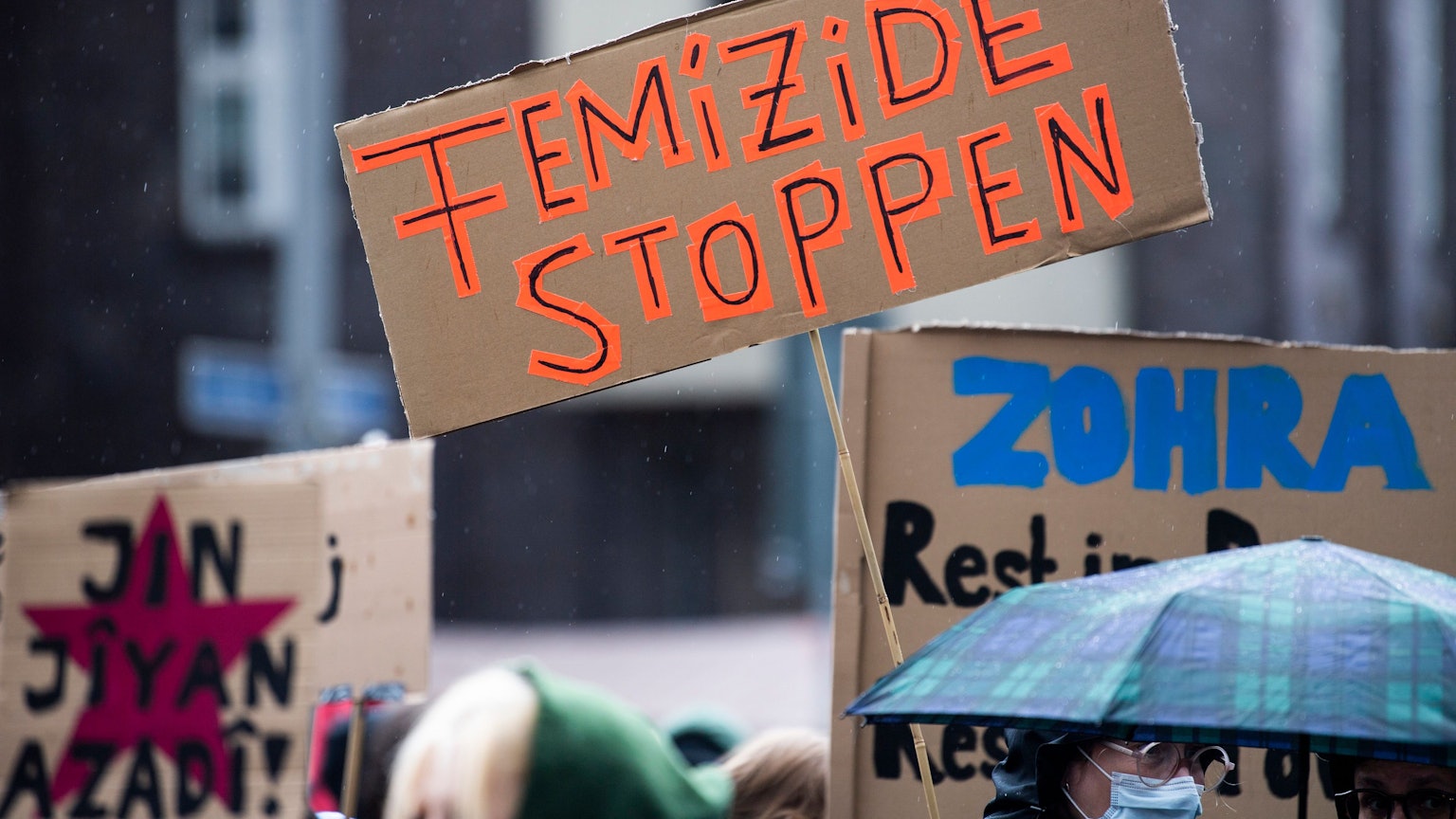 Bei einer Demonstration gegen Gewalt an Frauen hält eine Teilnehmerin ein Plakat mit der Aufschrift „Femizide stoppen“.