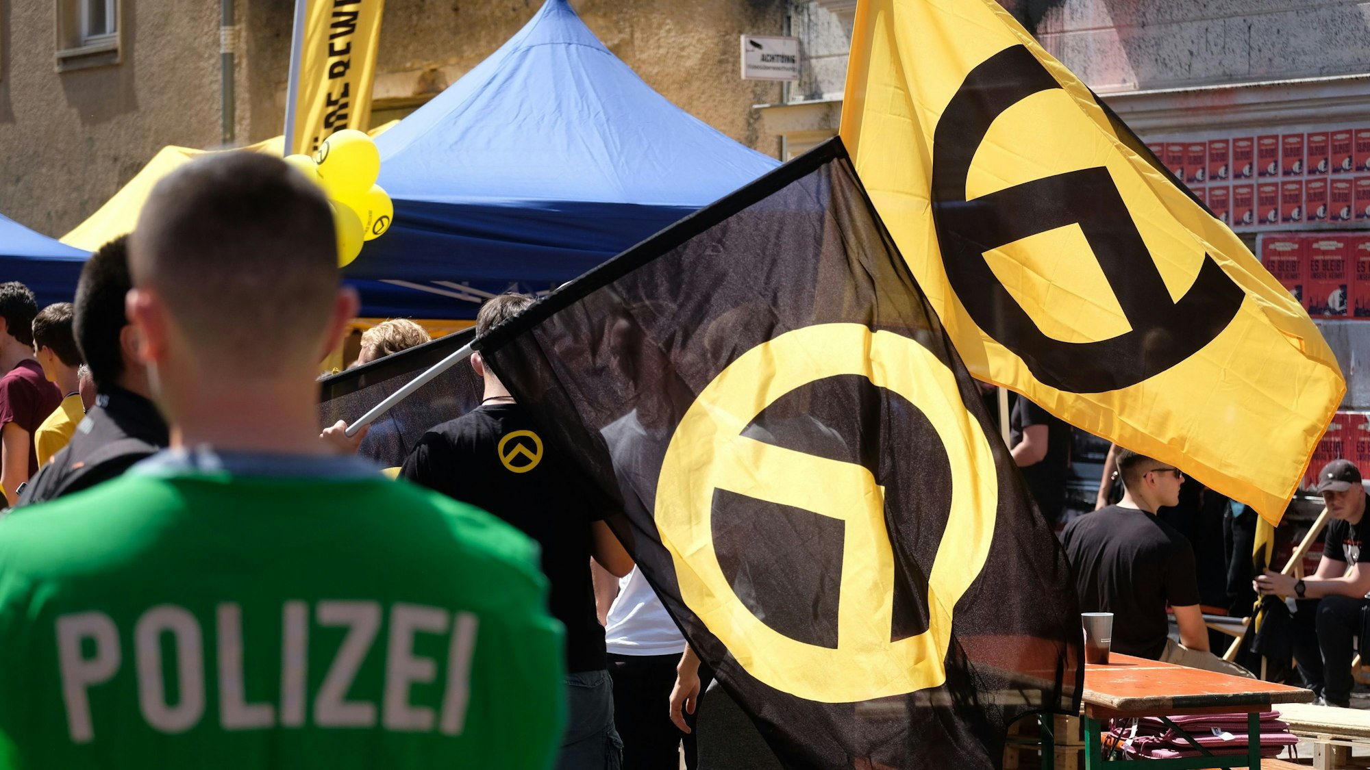 Ein Polizist beobachtet Teilnehmer einer Versammlung der rechtsextremen Identitären Bewegung.