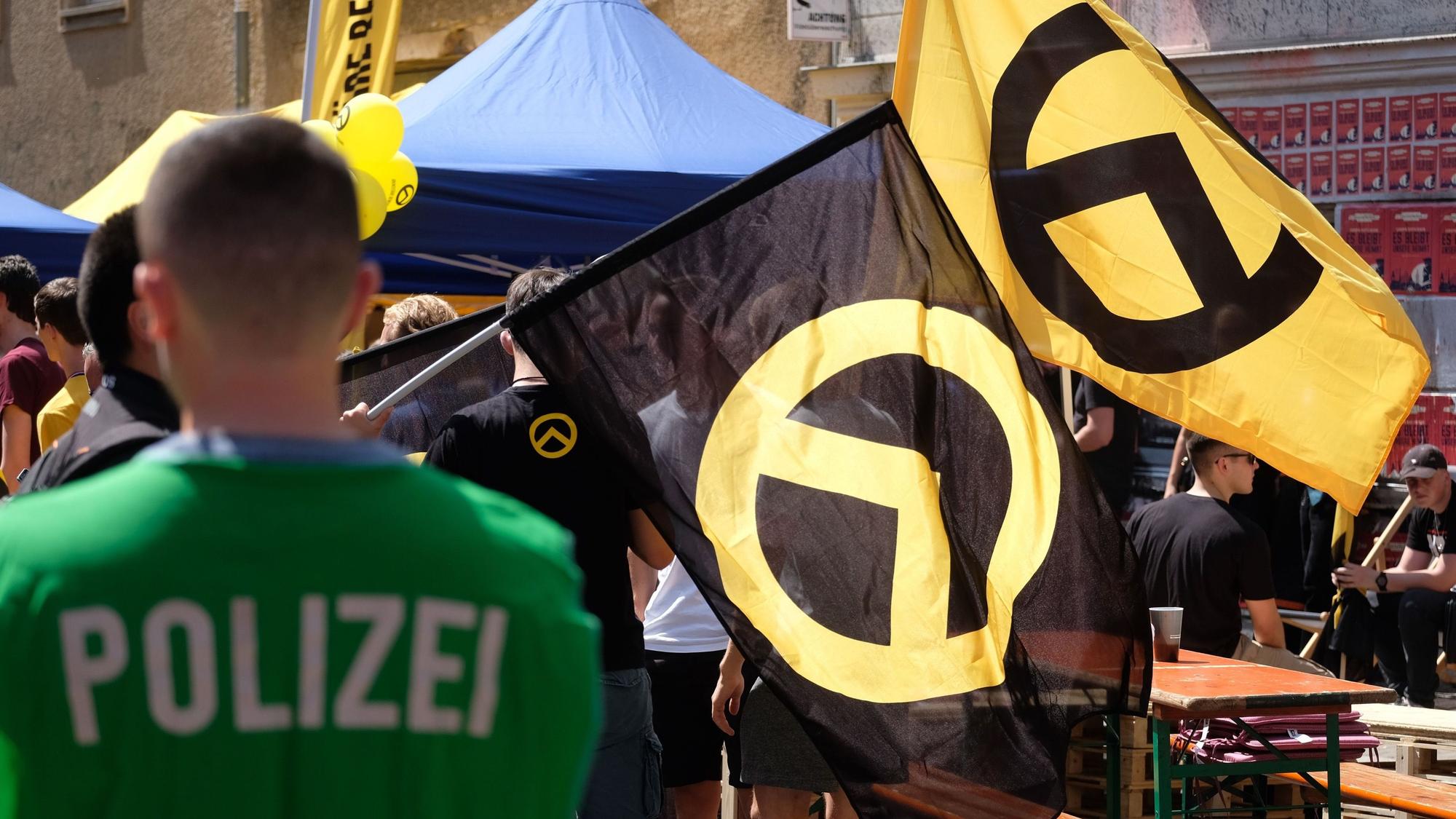 Ein Polizist beobachtet Teilnehmer einer Versammlung der rechtsextremen Identitären Bewegung.