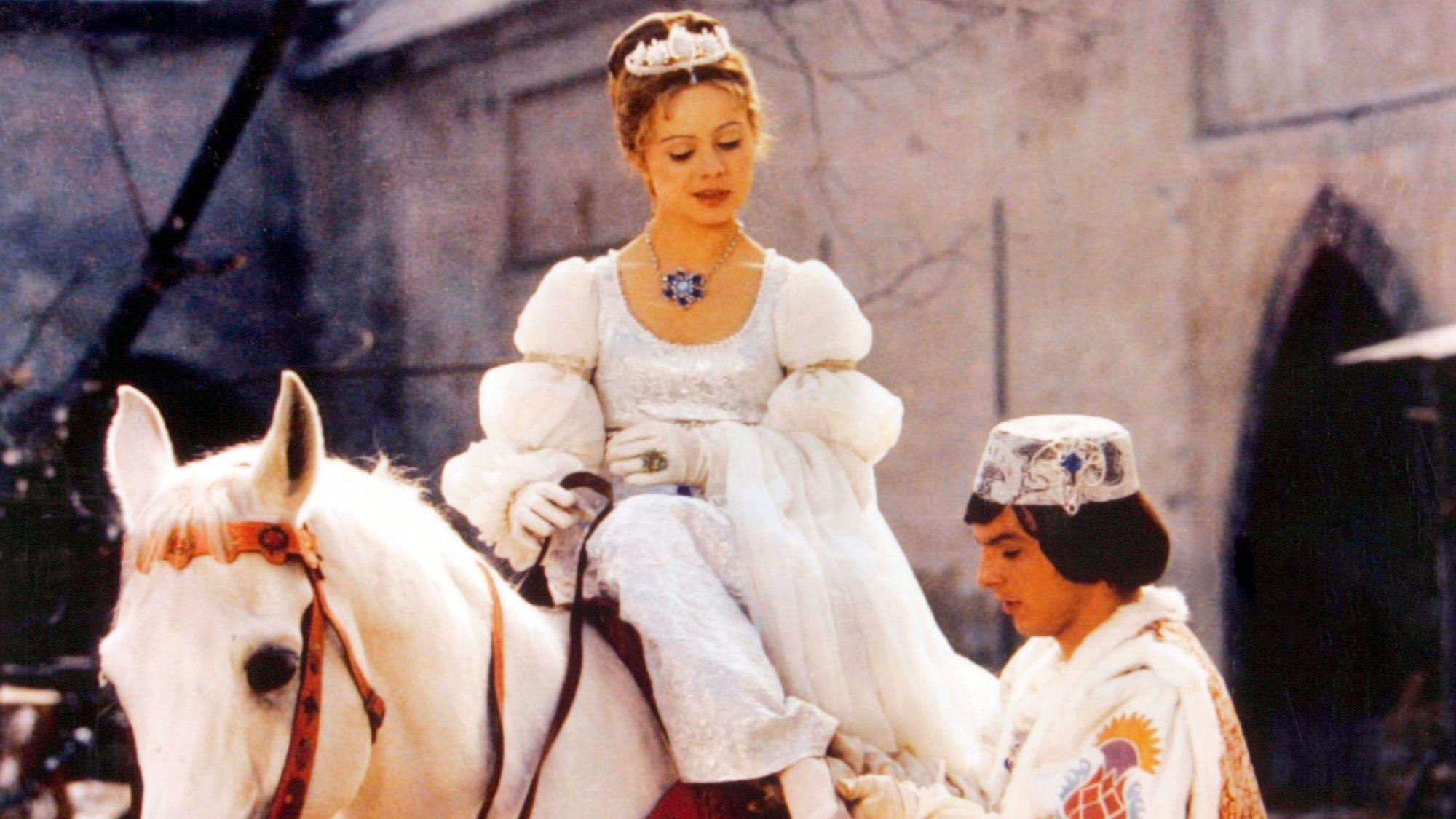Der Prinz (Pavel Trávníček) passt Aschenbrödel (Libuše Šafránková) im Film „Drei Haselnüsse für Aschenbrödel“ den verlorenen Schuh an.