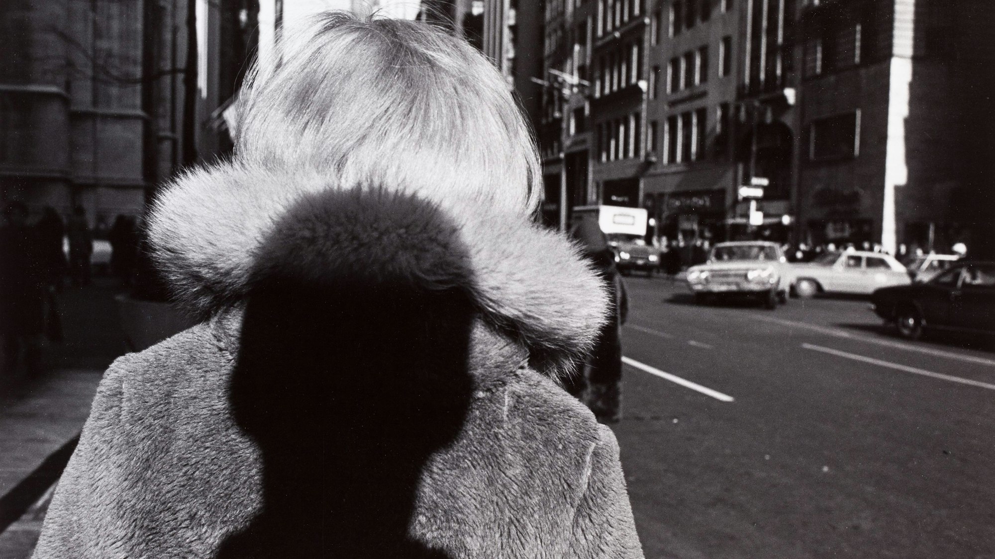 Der Schatten eines Mannes fällt auf den Rücken einer Frau.