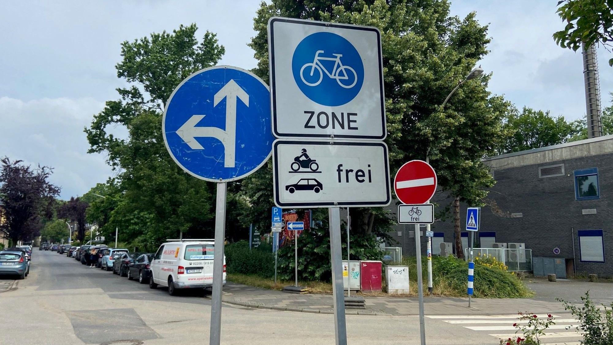 Auf dem Bild sind Verkehrsschilder rund um eine Radzone zu sehen.