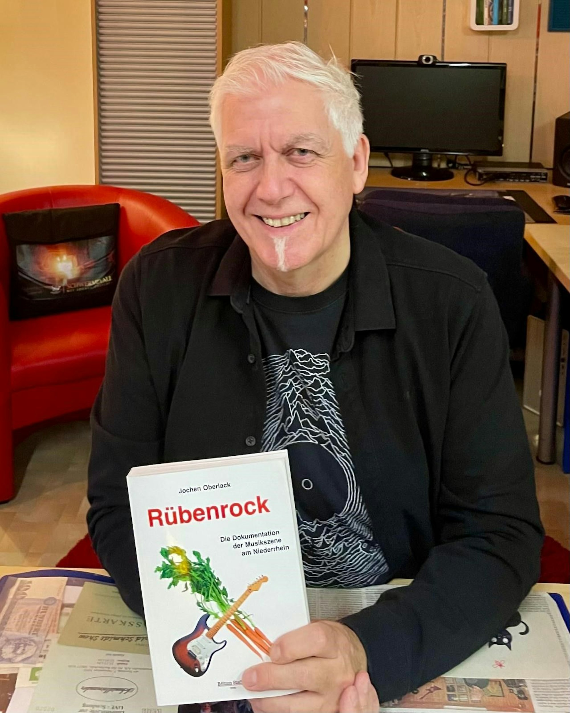 Jochen Oberlack präsentiert das Buch in den Händen