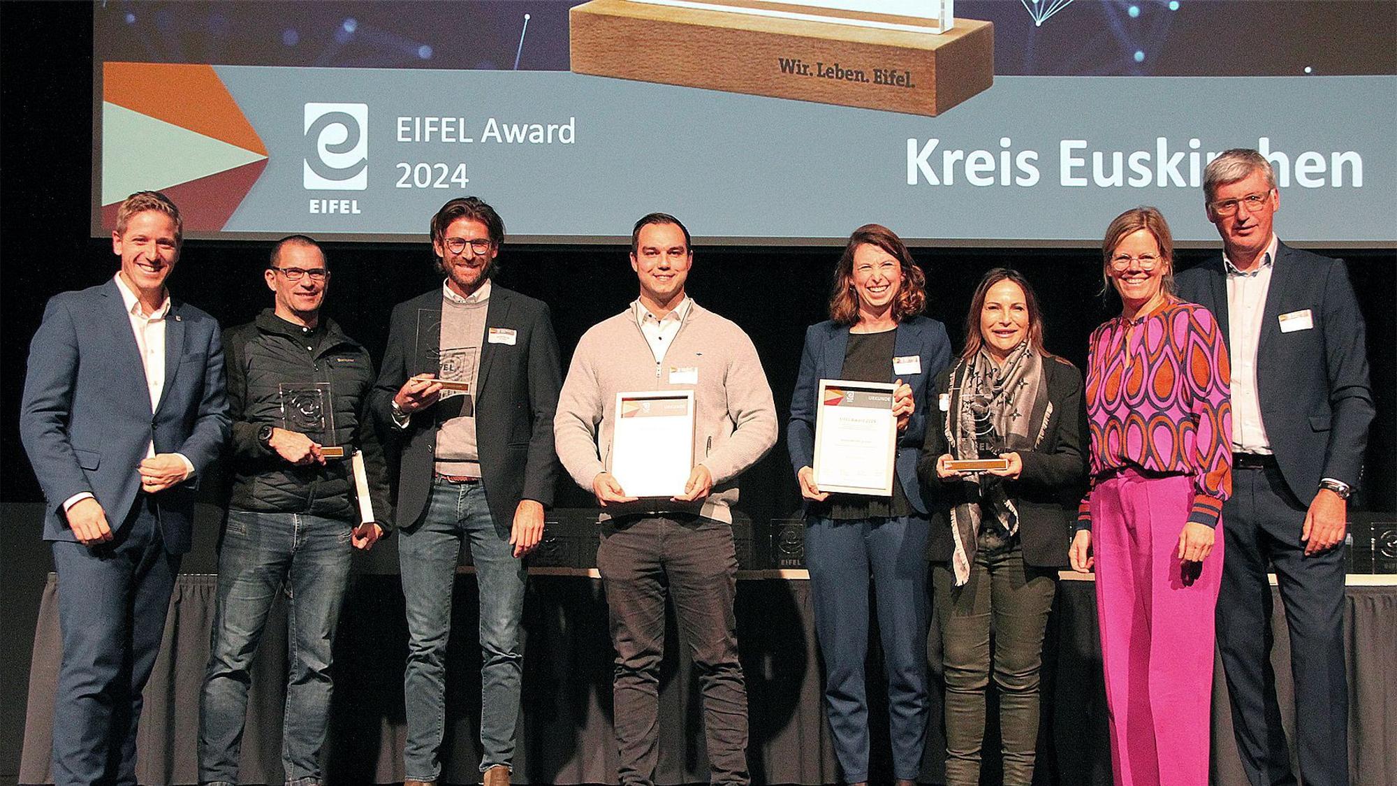 Mehrere Menschen zeigen Auszeichnungen auf der Bühne der Eifel Awards 2024.