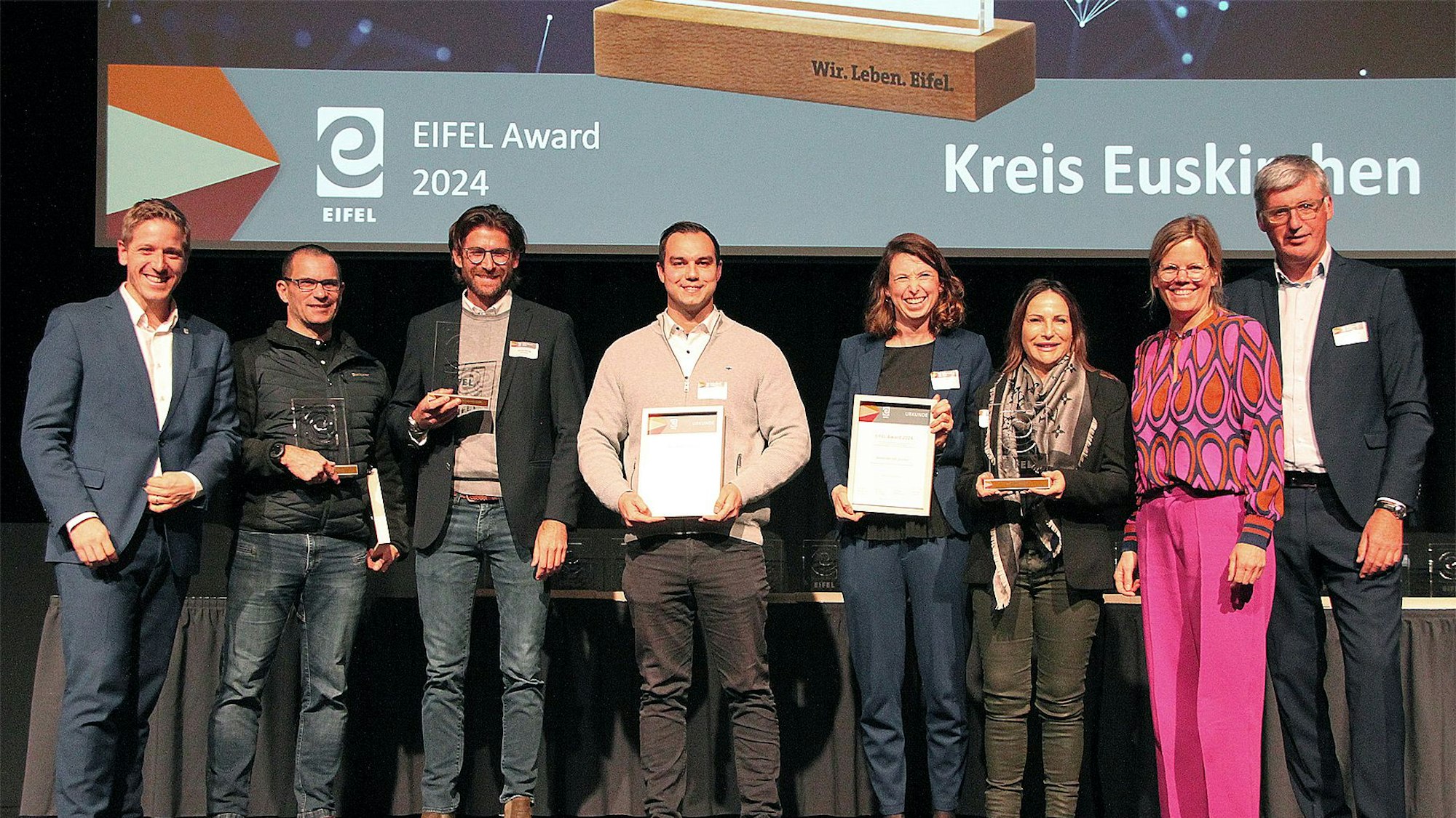 Mehrere Menschen zeigen Auszeichnungen auf der Bühne der Eifel Awards 2024.