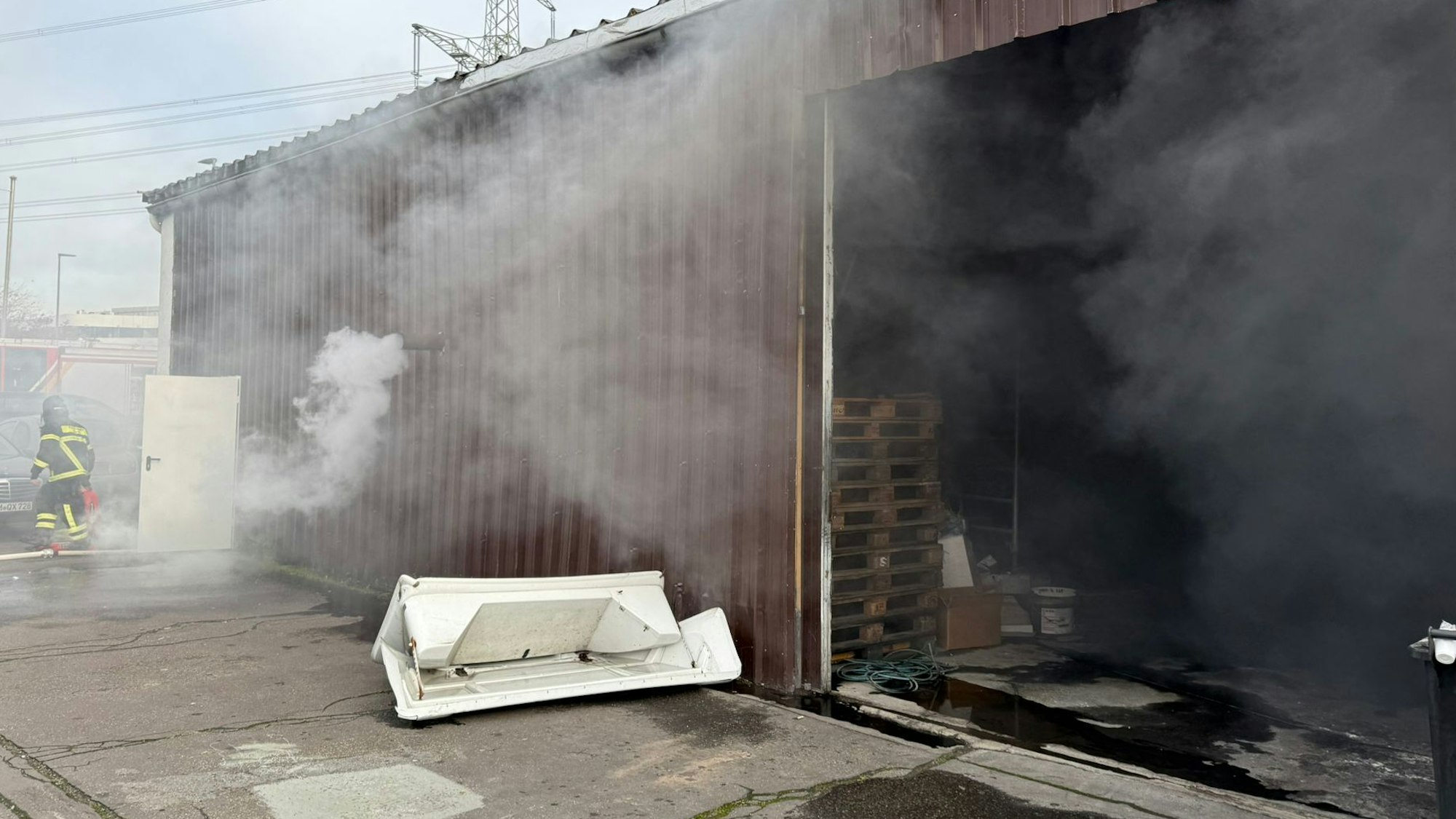 Dicker Rauch drang aus der Halle. In schwerem Atemschutz rückte die Feuerwehr zum Brand vor.