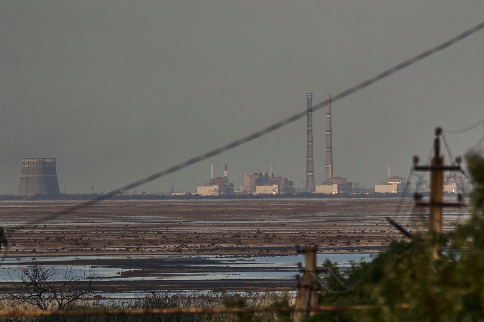 Blick über den jetzt leeren Stausee: Europas größtes Kernkraftwerk Saporischschja ist hinter dem Kachowka-Stausees nach einem Dammbruch in der russisch besetzten Ukraine zu sehen.