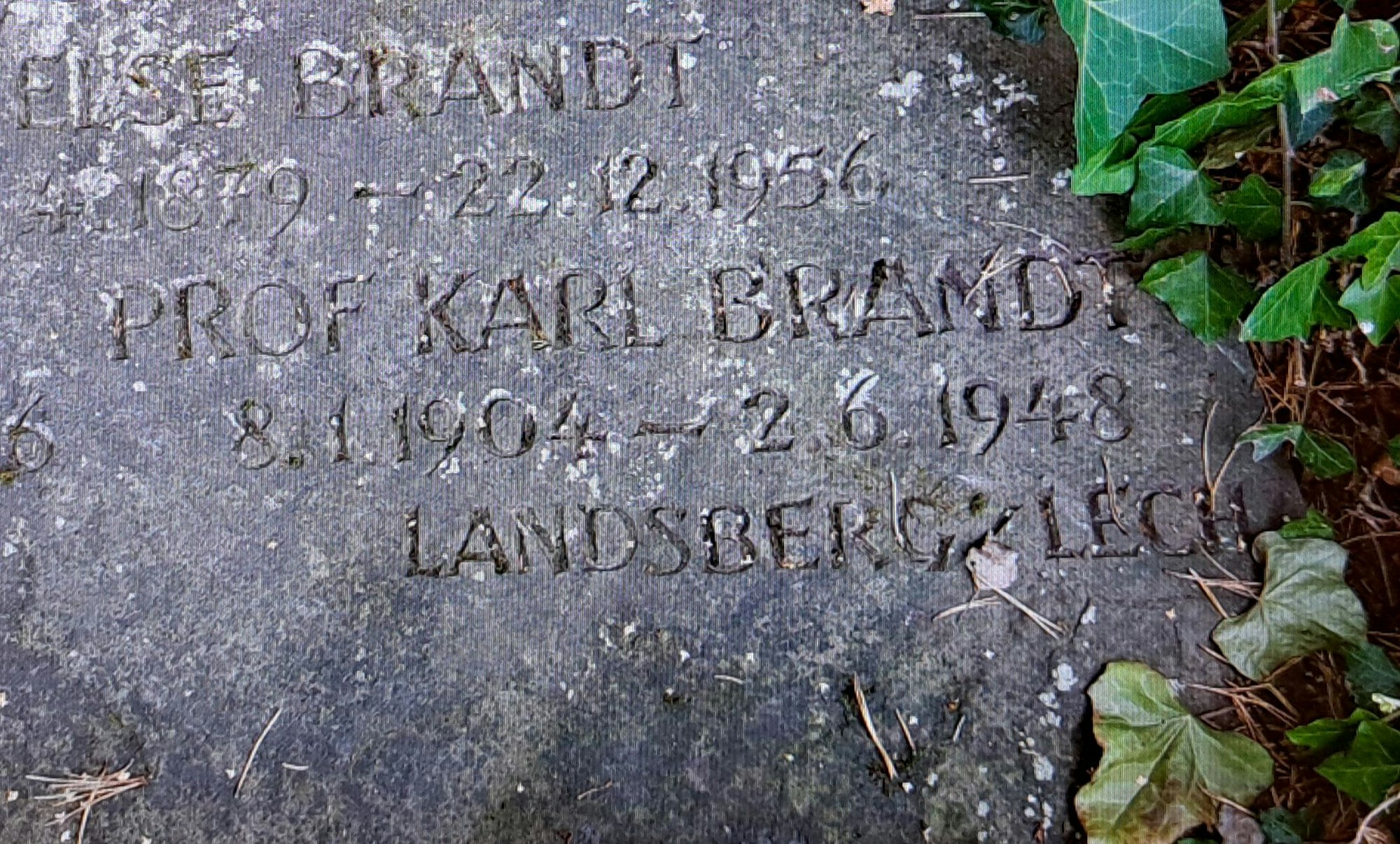 Das Foto zeigt den Grabstein mit der Inschrift "Prof. Karl Brandt, 8.1.1904-2.6.1948, Landsberg /Lech