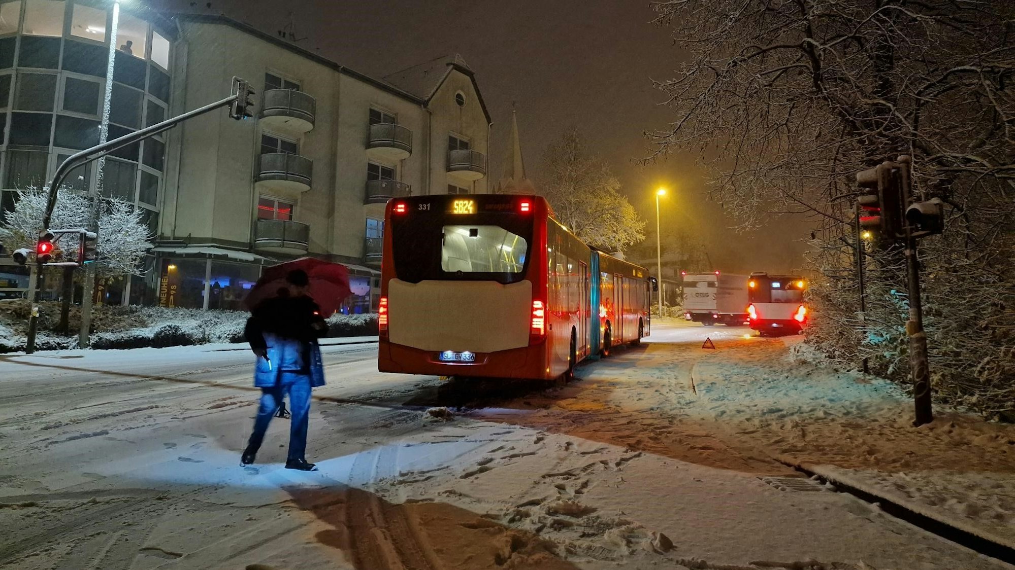 Busse stehen auf einer schneebedeckten Straße.