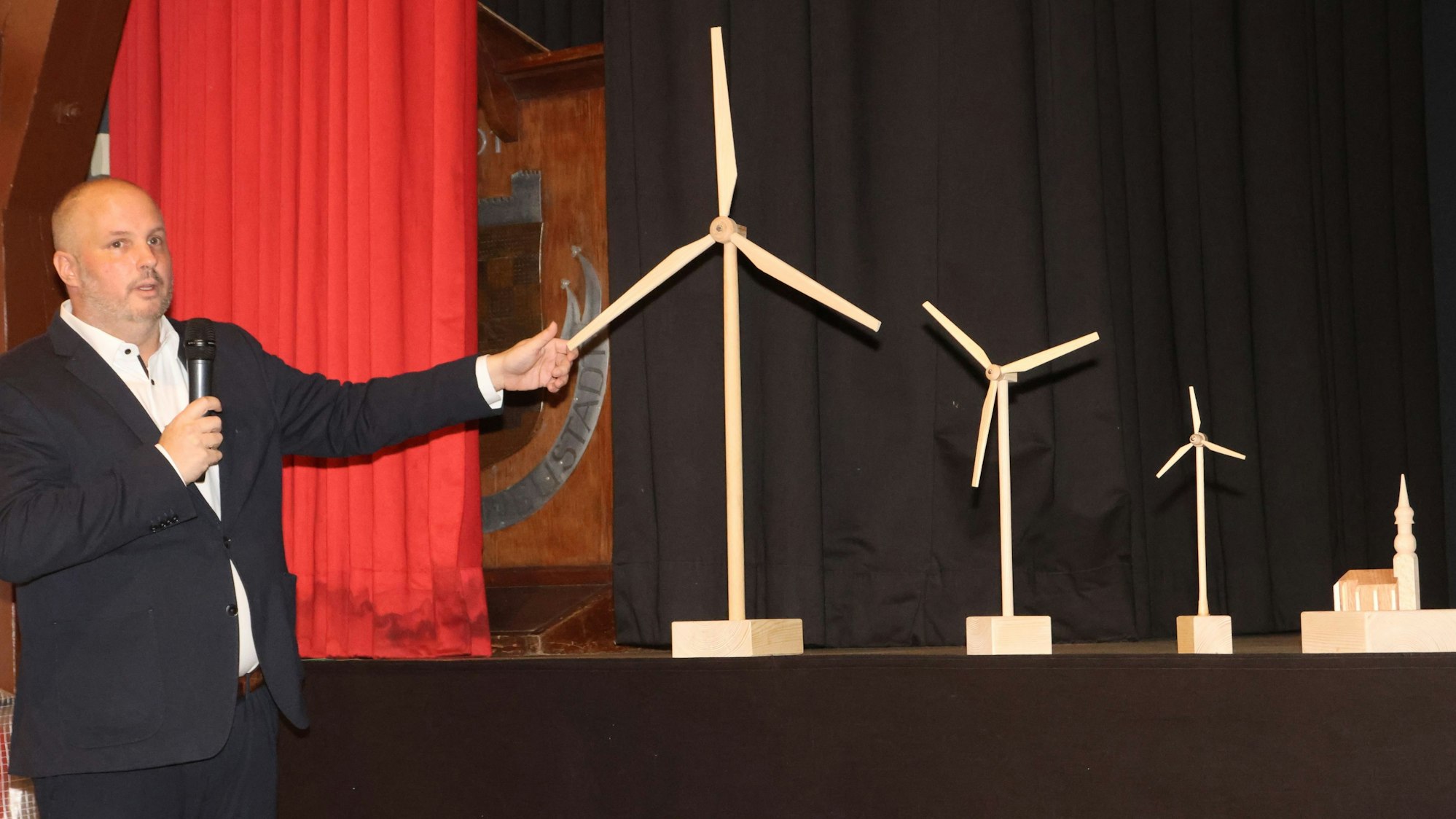 Matthias Thul demonstriert das Größenverhältnis der neuen Windräder im Vergleich zu bestehenden Gebäuden