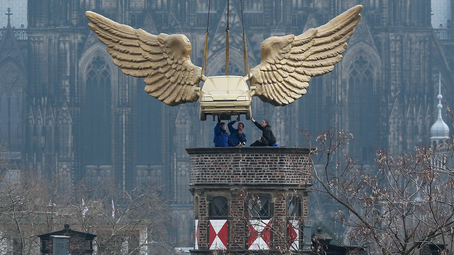 April 2013: Das Flügelauto des Aktionskünstlers HA Schult hängt an einem Kran und wird nach einer Restaurierung auf den Turm des Kölnischen Stadtmuseums in Köln gesetzt.