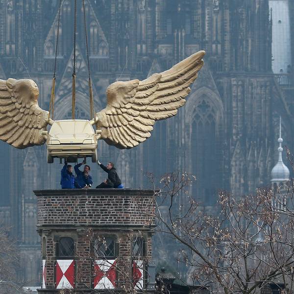 Das Flügelauto des Aktionskünstlers HA Schult hängt an einem Kran und wird2013 nach einer Restaurierung auf den Turm des Kölnischen Stadtmuseums in Köln gesetzt.