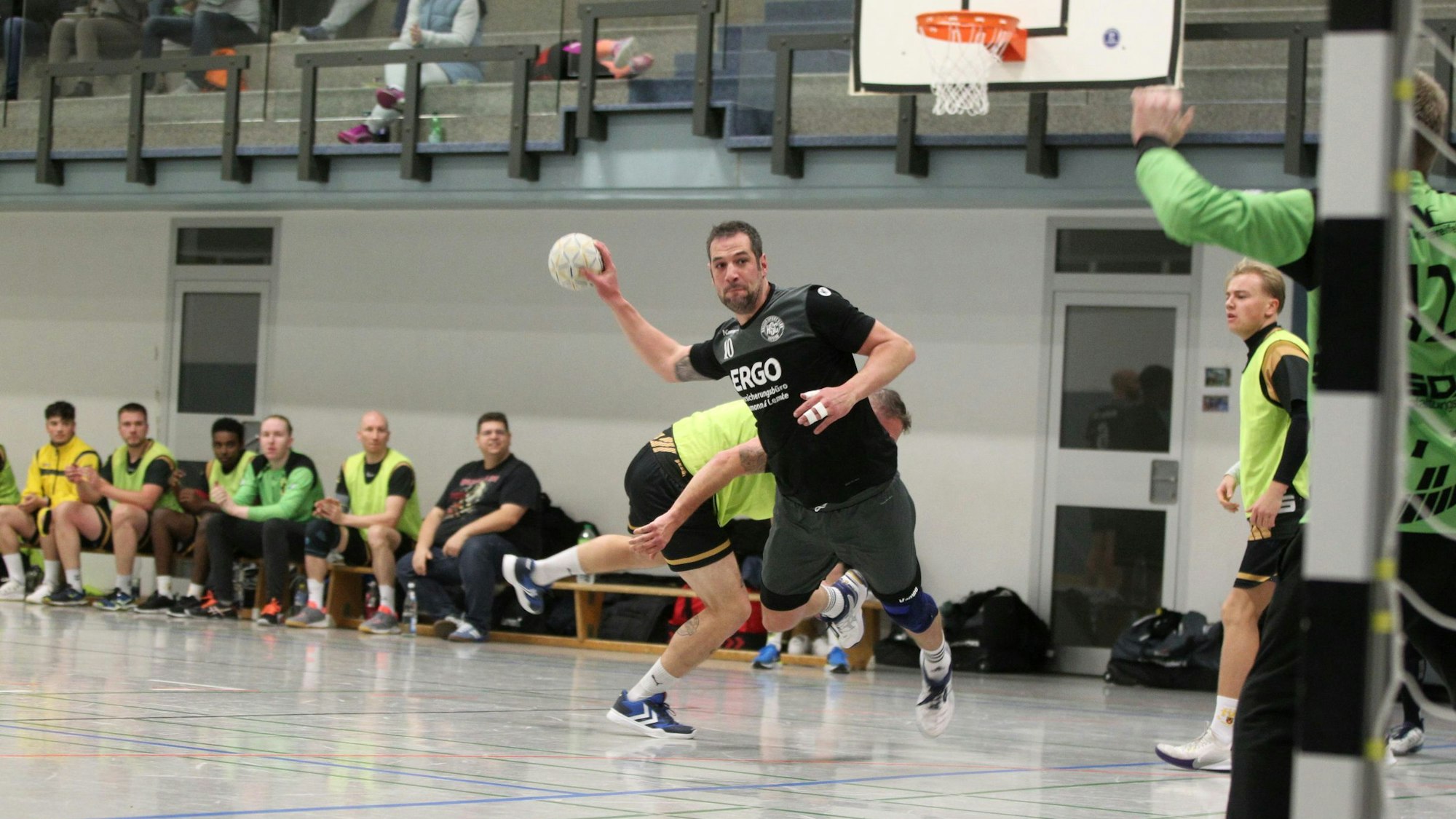 Simon Wilms beim Wurf auf das Tor, im Hintergrund schauen andere Spieler zu.