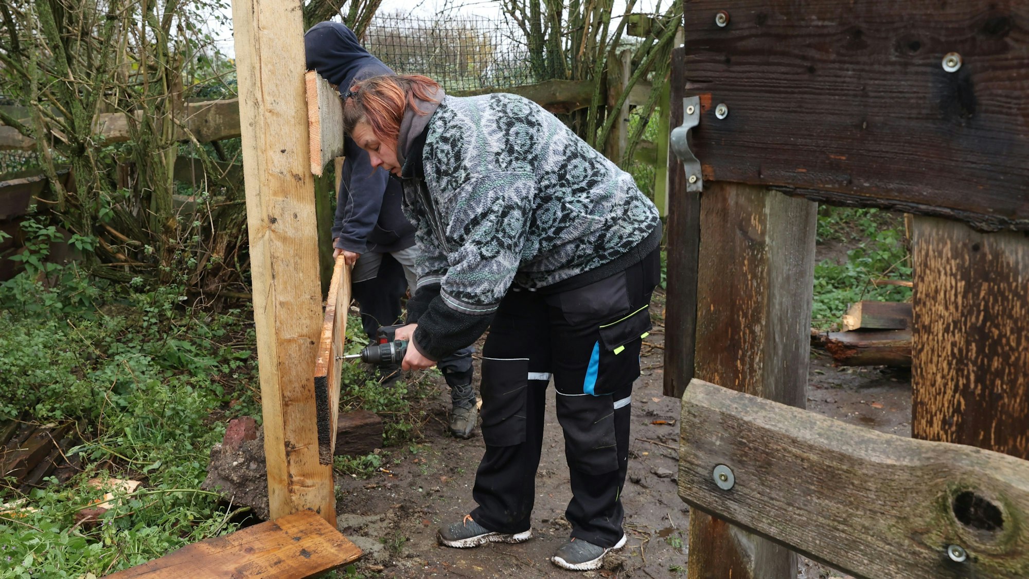 Yvonne Hannes repariert einen Holzzaun.
